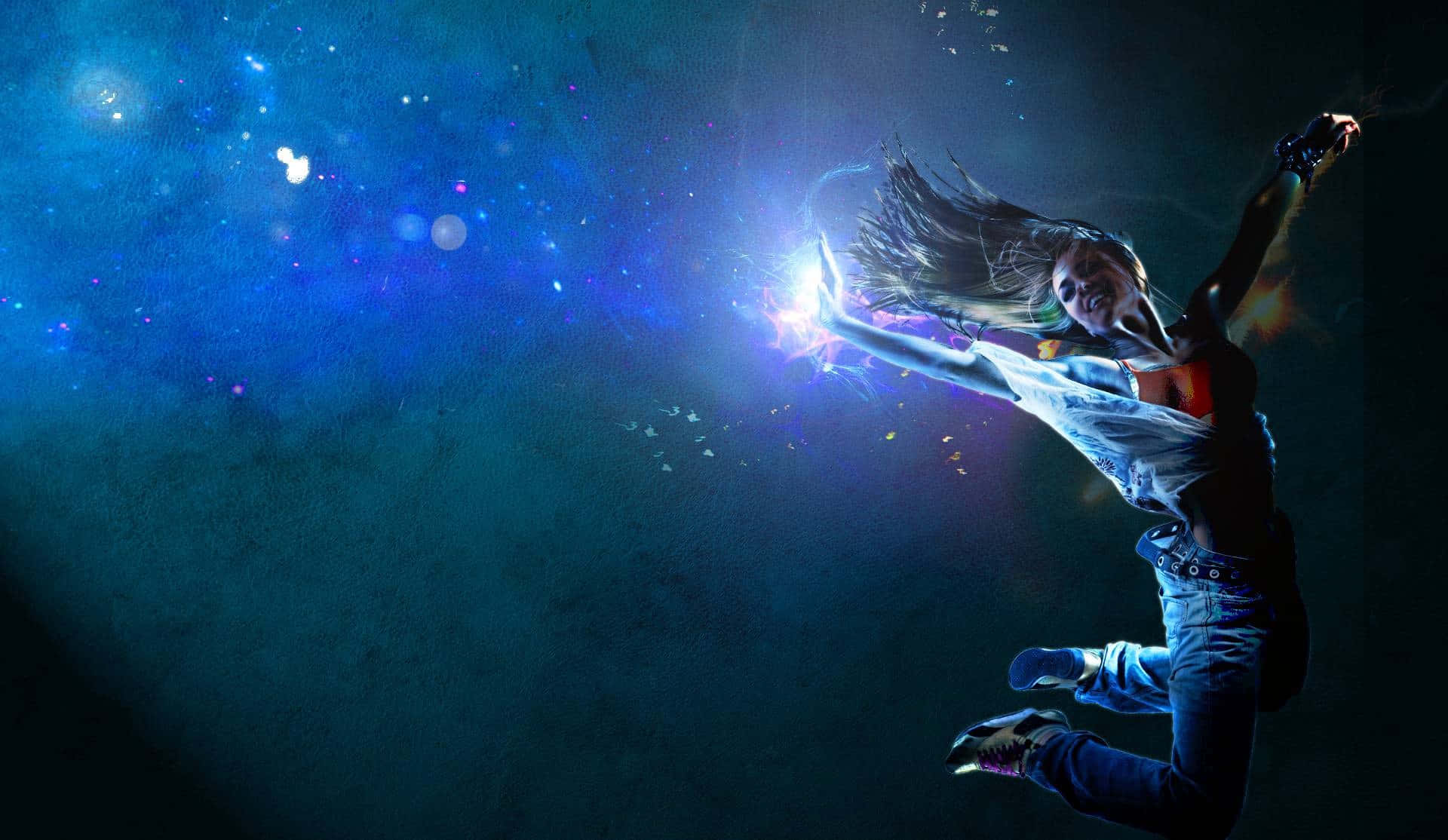 舞蹈 桌布 壁紙 — 一個人動態地跳躍，背景是帶有發光粒子和星狀光點的宇宙藍色背景。