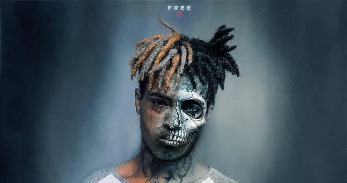 XXXTENTACION 桌布 壁紙 — 一個人化上半邊骷髏妝、留橙色辮子，在深灰色背景前凝視。