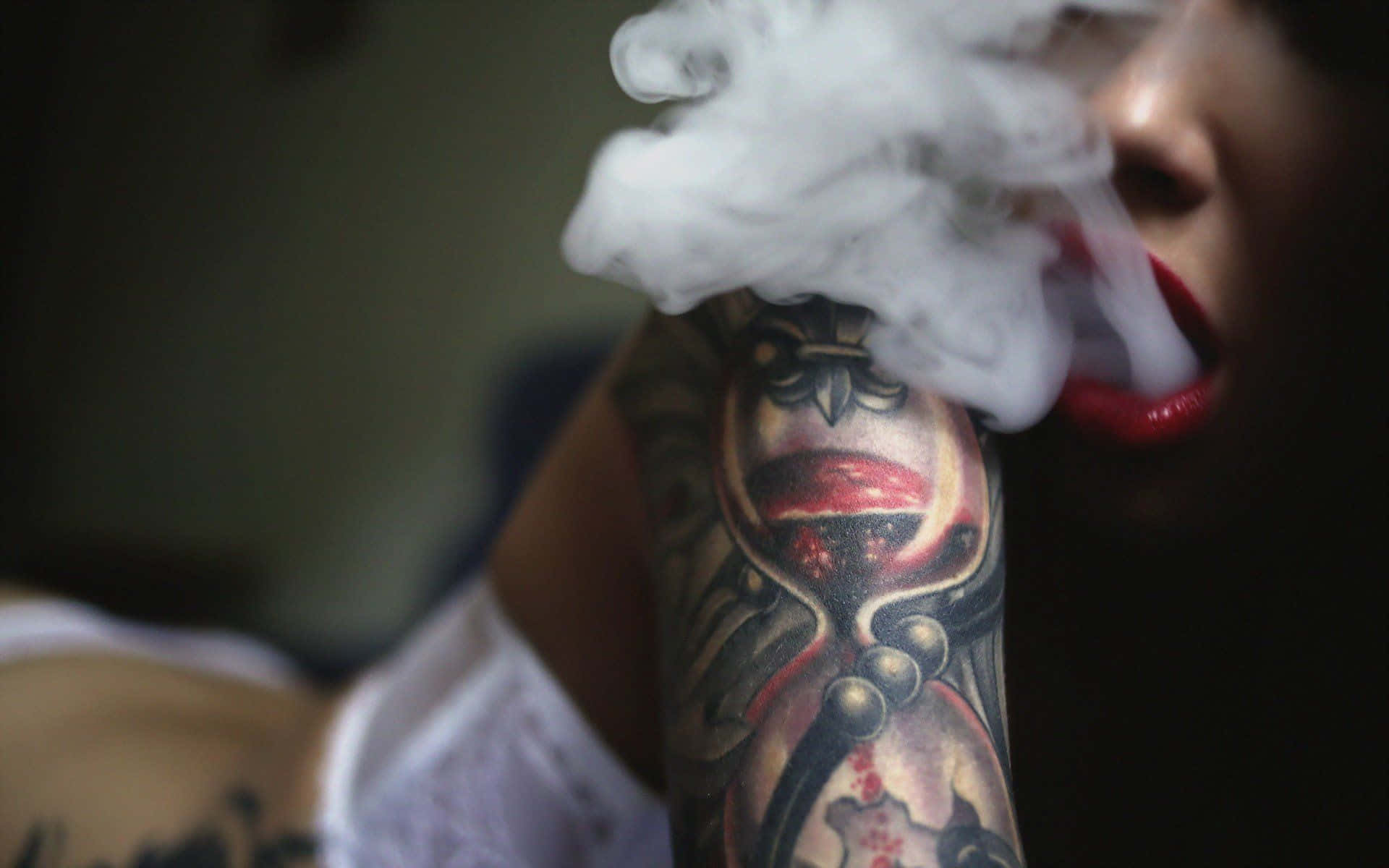 Tattoo 桌布 壁紙 — 一個人呼出濃濃的蒸氣，同時展示手臂上精細的沙漏紋身。