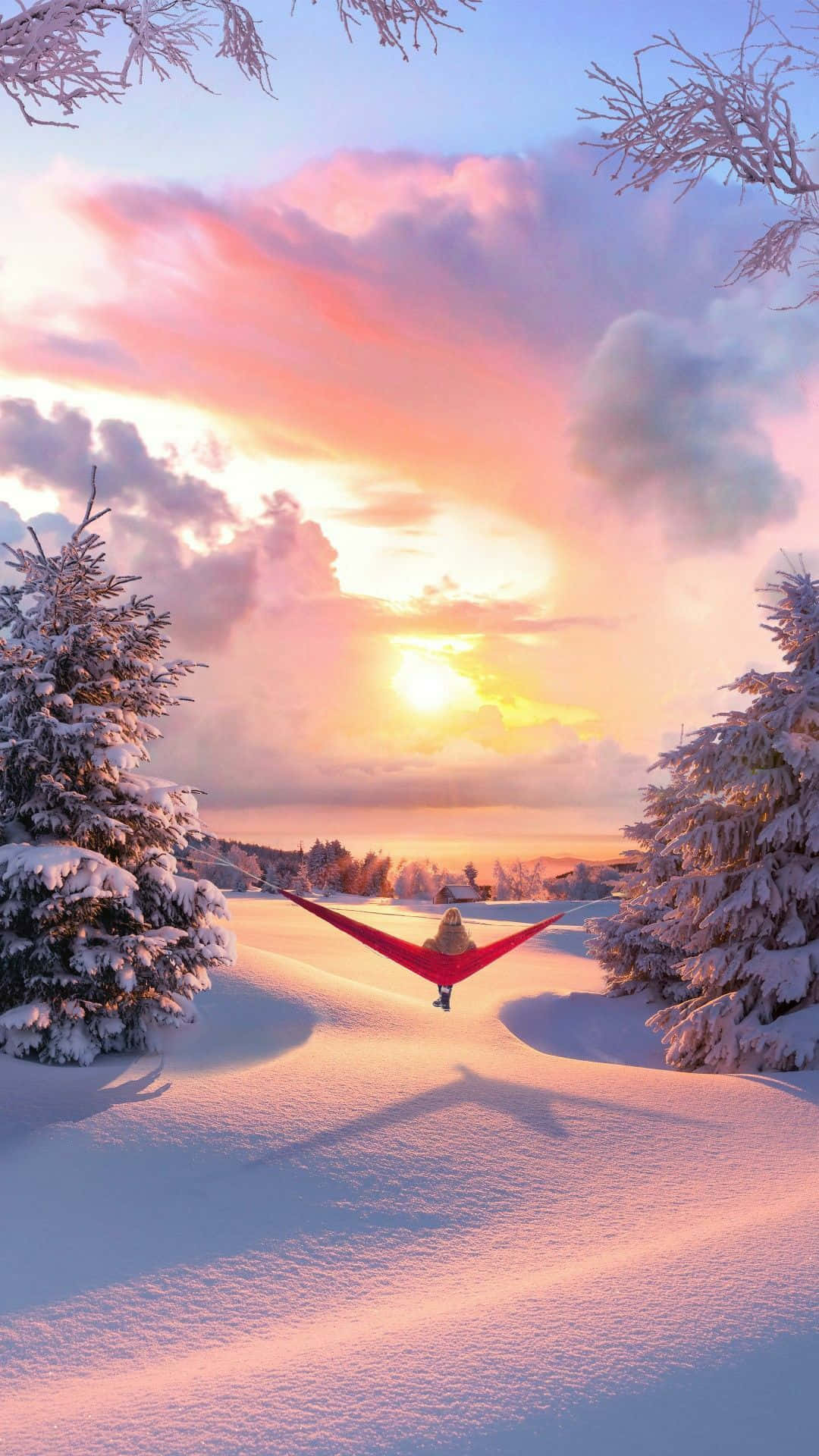 Cute Winter Aesthetic 桌布 壁紙 — 一個人在懸掛於積雪松樹之間的紅色吊床上放鬆，而充滿活力的日落將冬日天空染成粉紅色和金色。
