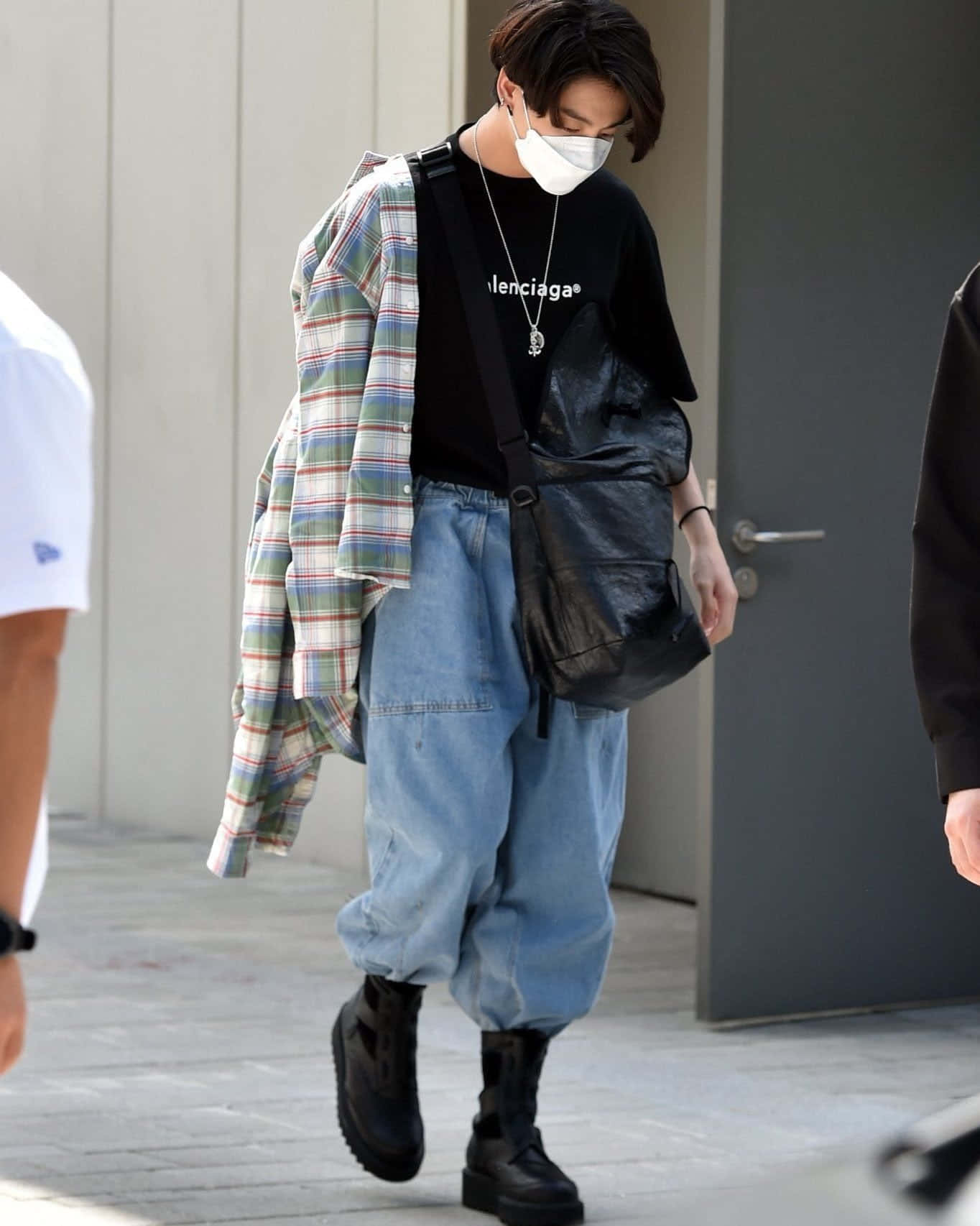 Jungkook 桌布 壁紙 — 一個人在戶外行走，身穿黑色Balenciaga T恤配格紋襯衫，寬鬆牛仔褲和黑色靴子，戴著口罩。