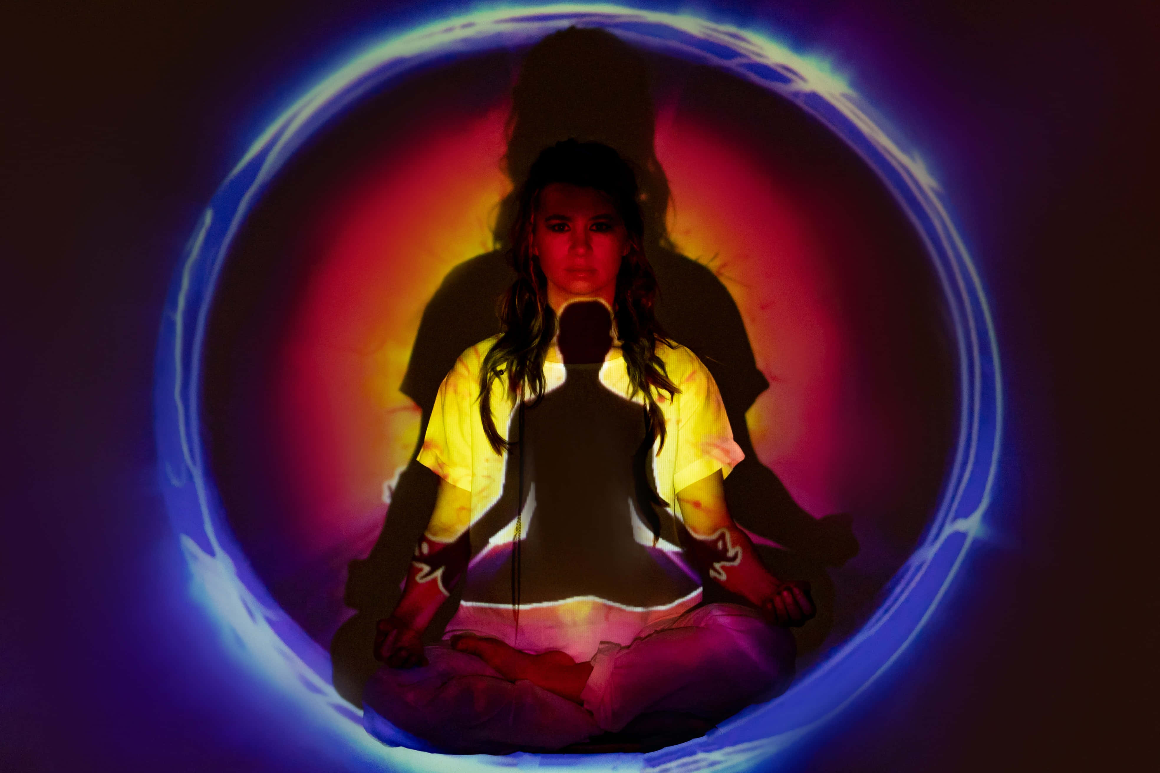 Reiki 桌布 壁紙 — 一個人在散發著鮮豔藍色和紅色光芒的圓形傳送門內盤腿冥想。