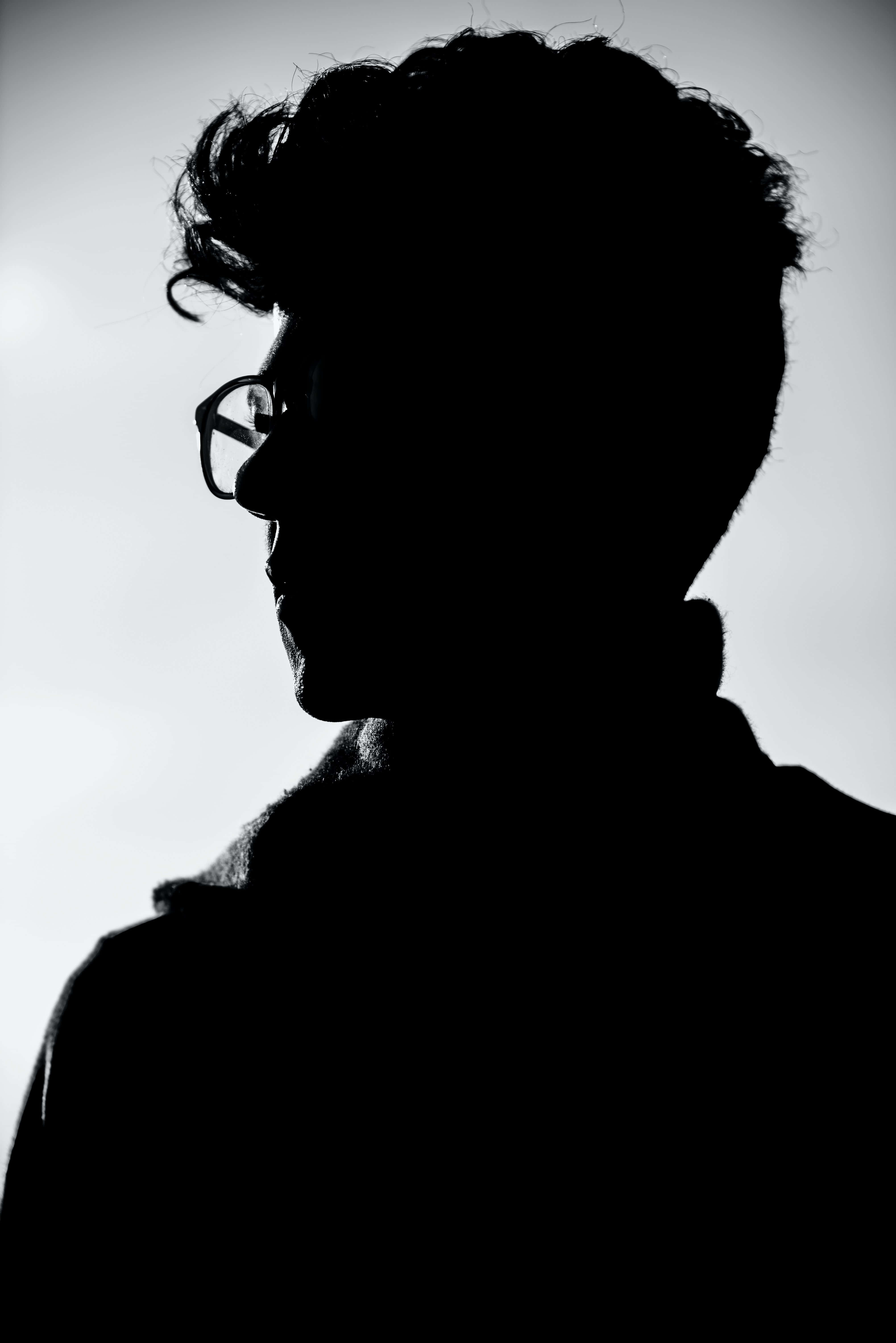Silhouette 桌布 壁紙 — 一個人在明亮背景下戴眼鏡的側面黑白剪影，對比鮮明。
