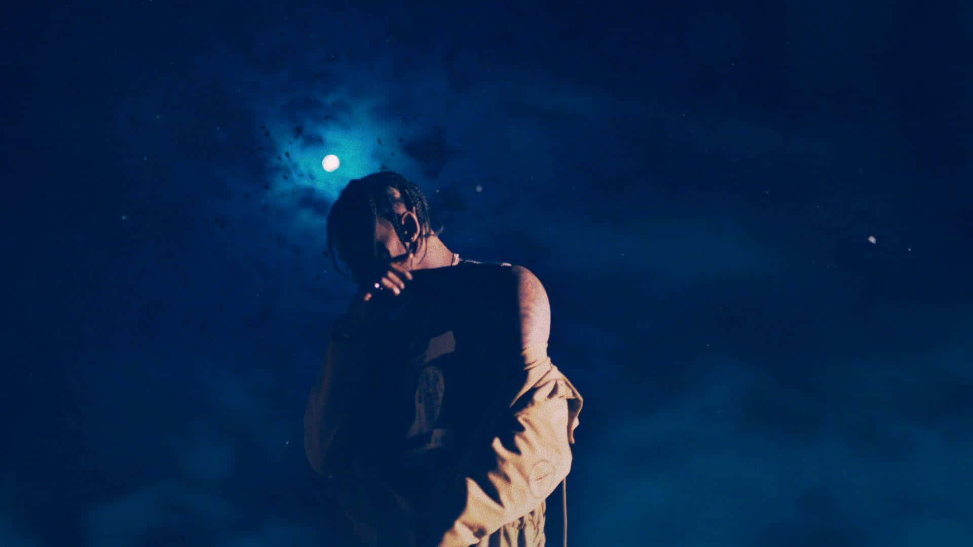 Astroworld 桌布 壁紙 — 一個人在昏暗的藍色場景中，背後有發光的月亮，手持香煙。
