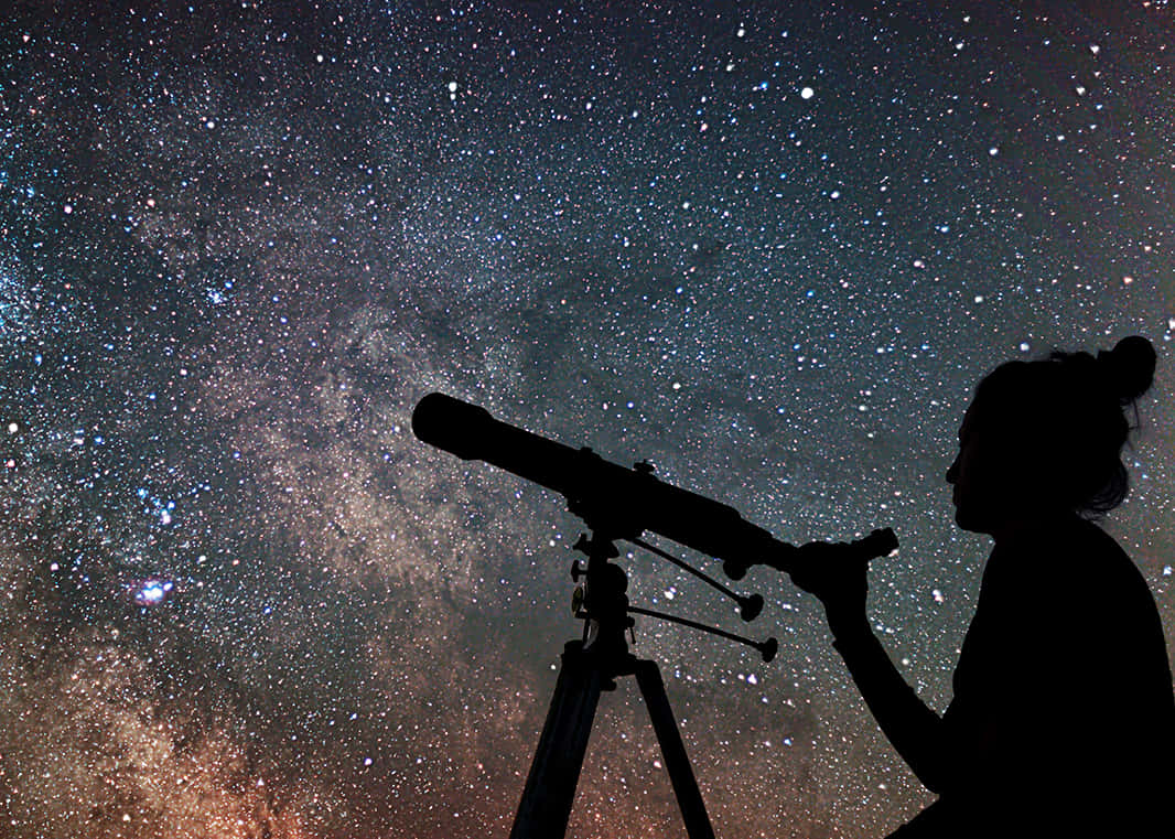 astronomy 桌布 壁紙 — 一個人在星空下使用望遠鏡觀看銀河系的剪影。
