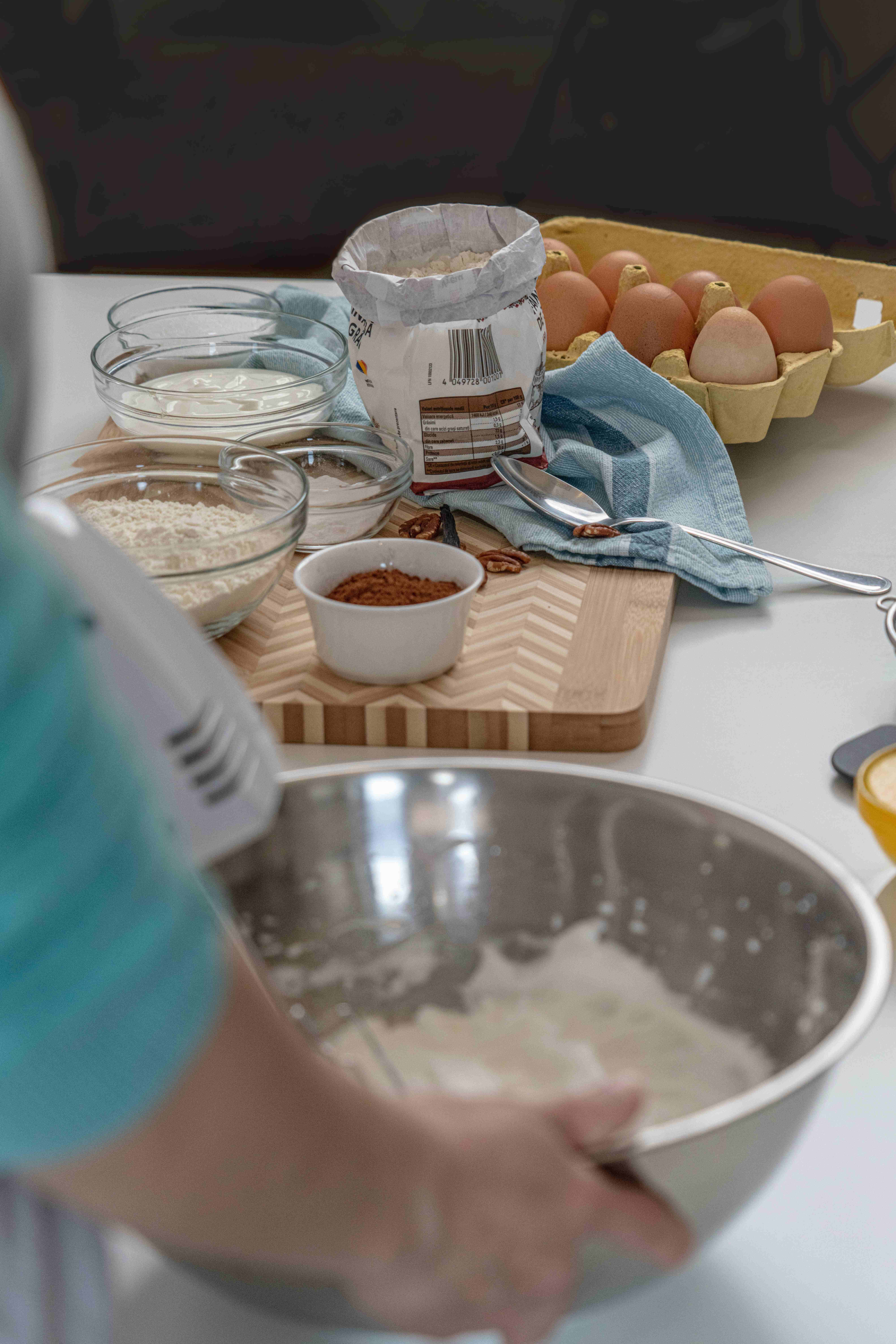 Baking 桌布 壁紙 — 一個人在木製砧板上，被烘焙材料包圍的金屬碗中混合麵糊。