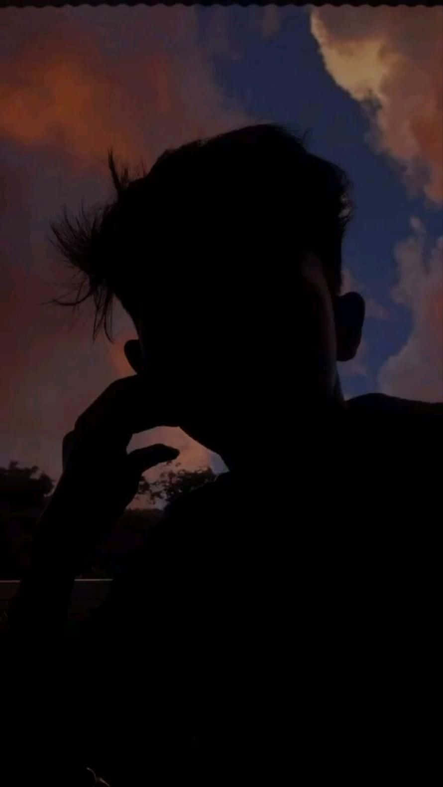 reflection 桌布 壁紙 — 一個人在沉思中的剪影，背景是充滿活力的黃昏天空，帶有橙色和藍色的雲彩。