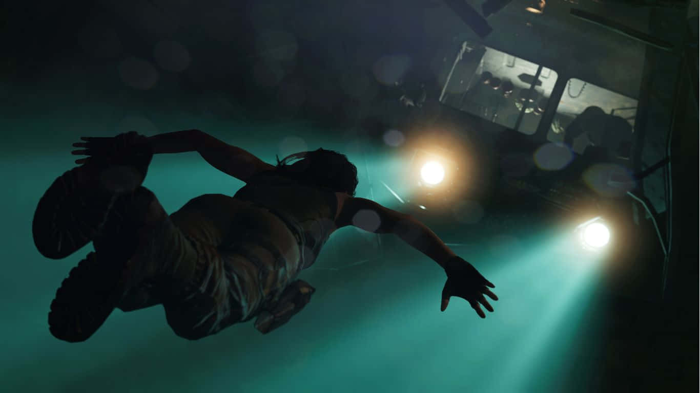 Lara Croft 桌布 壁紙 — 一個人在渾濁的綠色水中漂浮，朝向一輛被明亮車頭燈照亮的沉沒車輛。