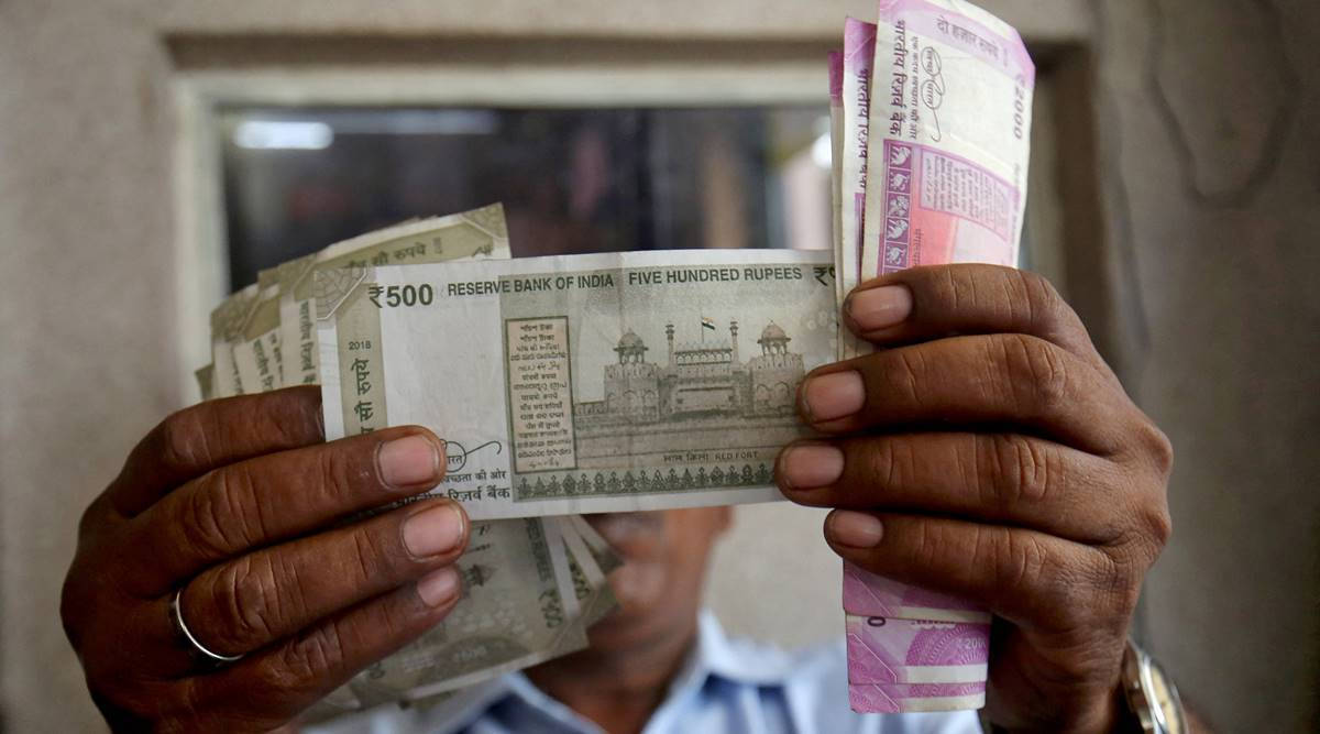 Indian 桌布 壁紙 — 一個人在特寫鏡頭中將一疊印度盧比紙幣拿在面前。