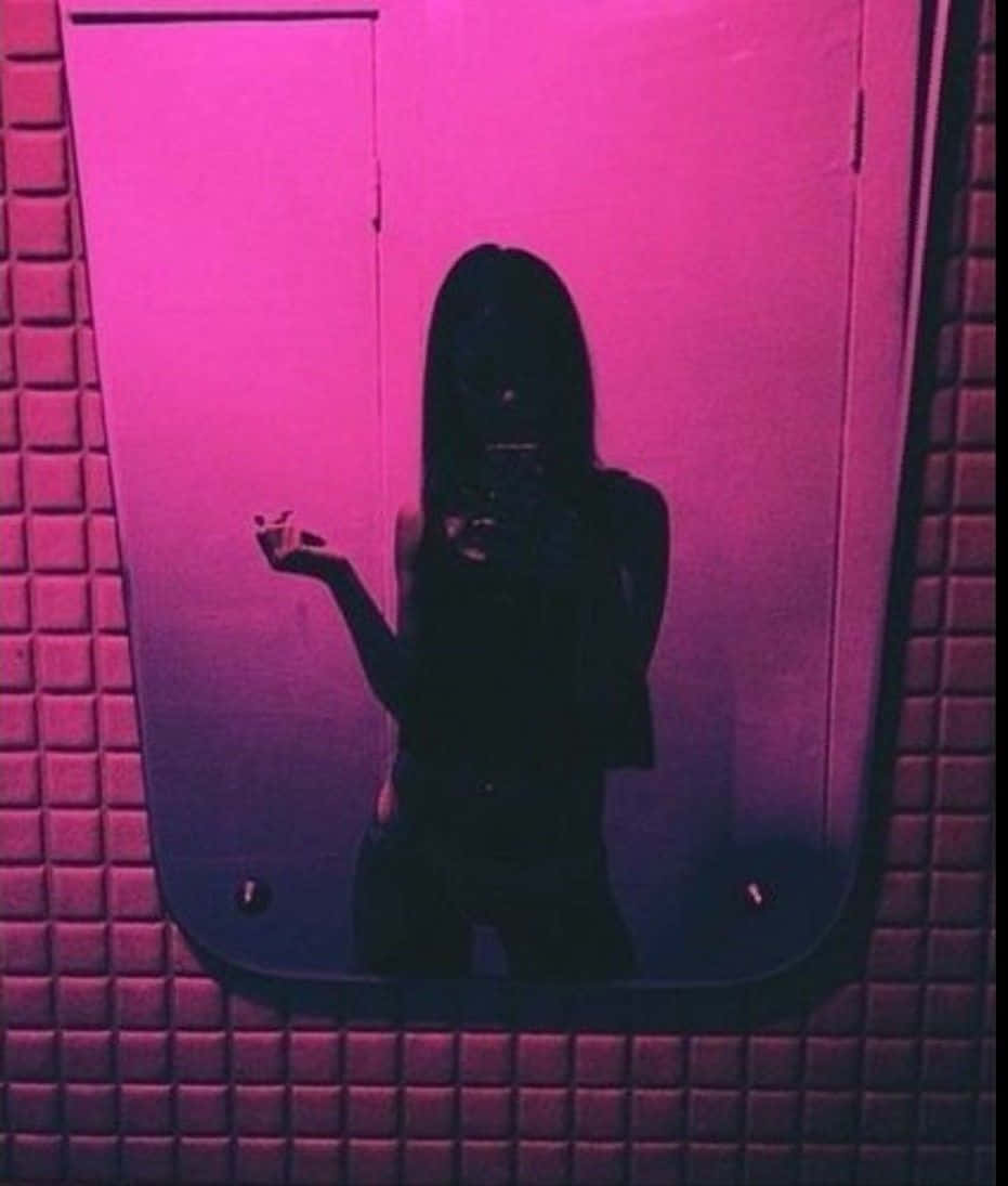 壞女孩美學 桌布 壁紙 — 一個人在粉紅色燈光的磁磚浴室中對著鏡子自拍的剪影。