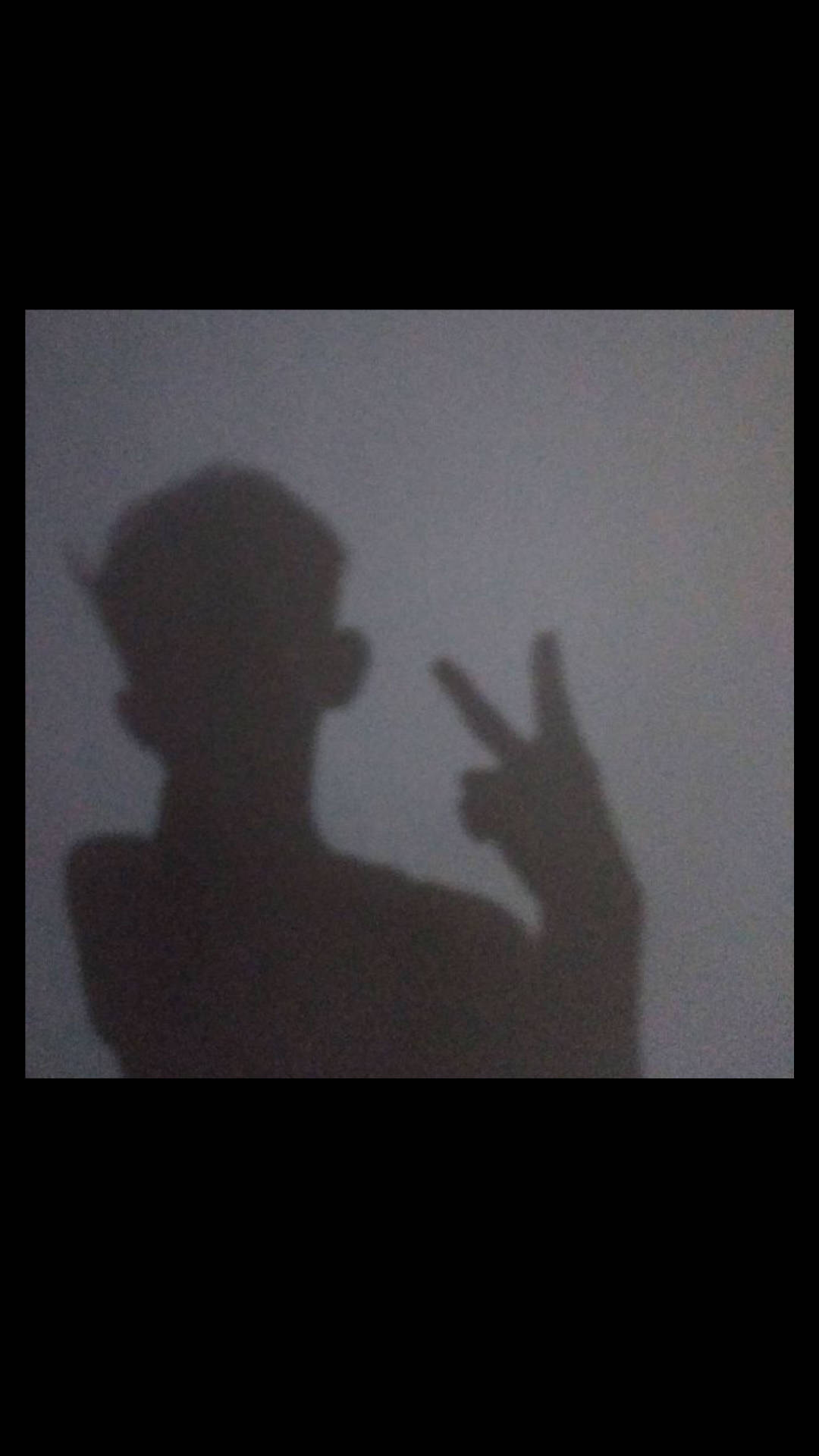 Boy 桌布 壁紙 — 一個人在純灰色牆壁前做出和平手勢的深色剪影，光線柔和。