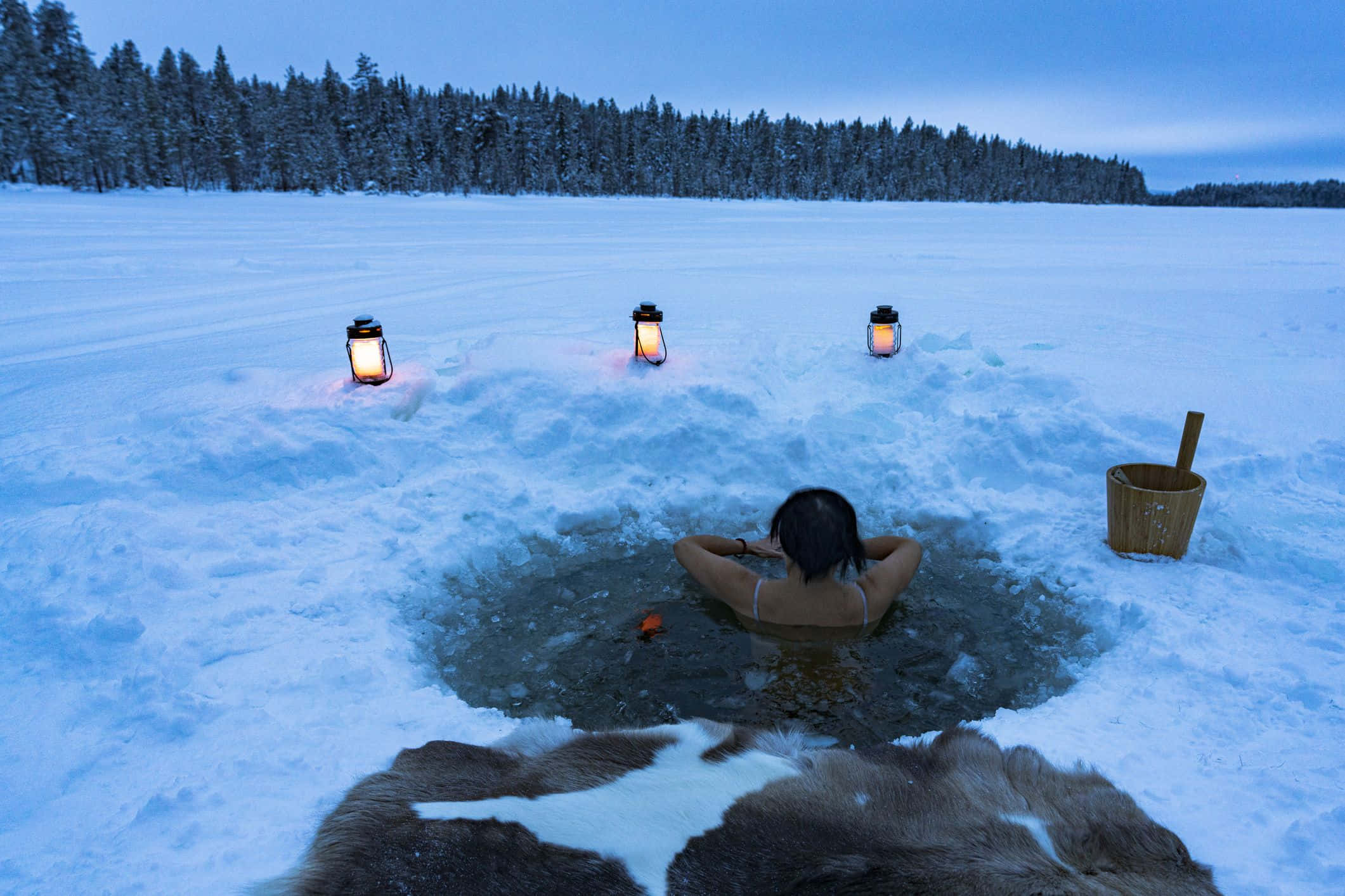 Cold 桌布 壁紙 — 一個人在被發光燈籠和暮色森林環繞的雪地冰洞浴中放鬆。