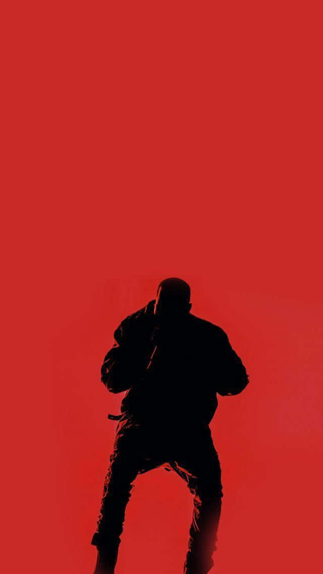kanye iPhone 桌布 壁紙 — 一個人在鮮紅色實色背景上蹲伏姿勢的鮮明黑色剪影。