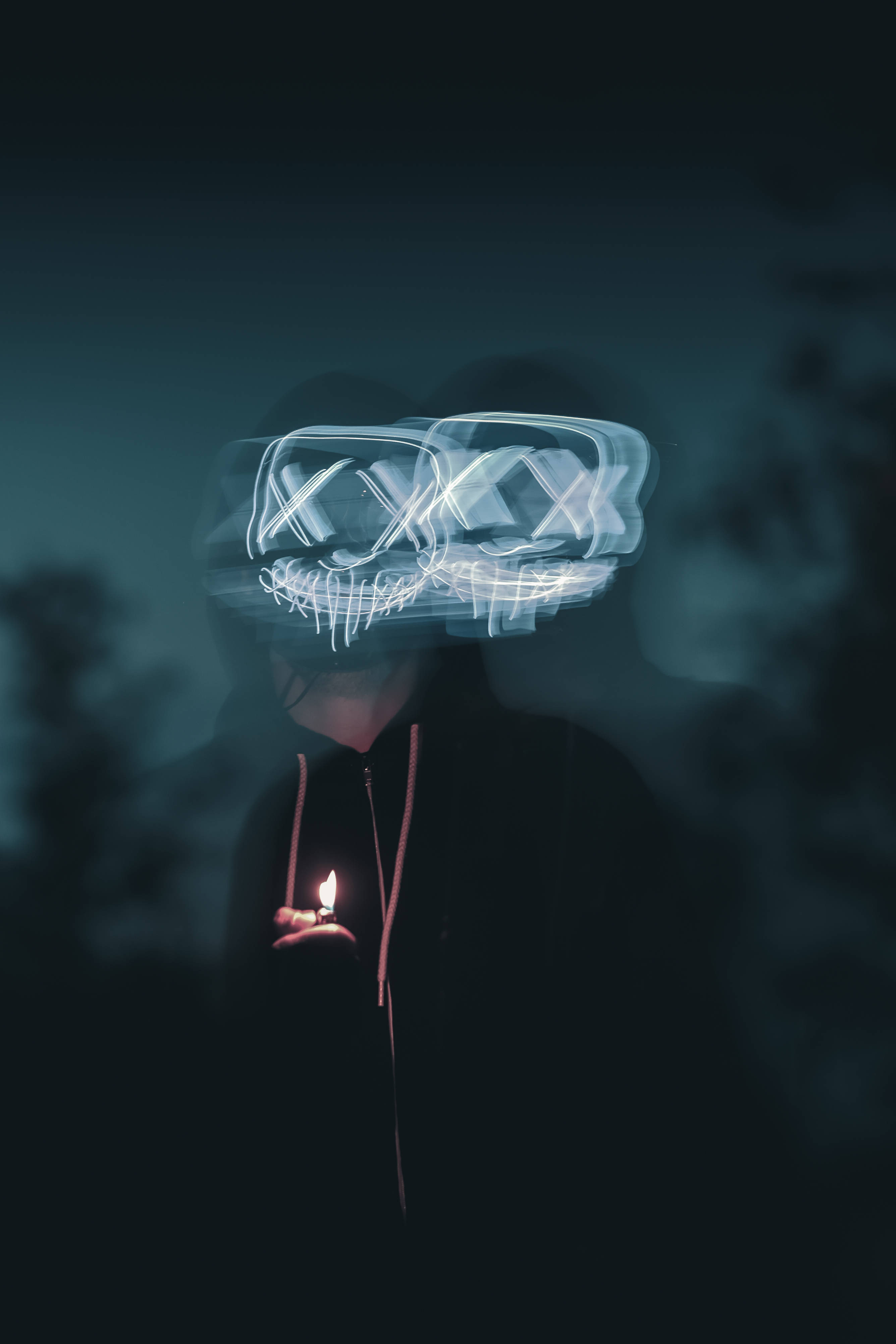 Purge 桌布 壁紙 — 一個人在黑暗中手持蠟燭，發光的軌跡在他們頭頂形成一個骷髏面具。