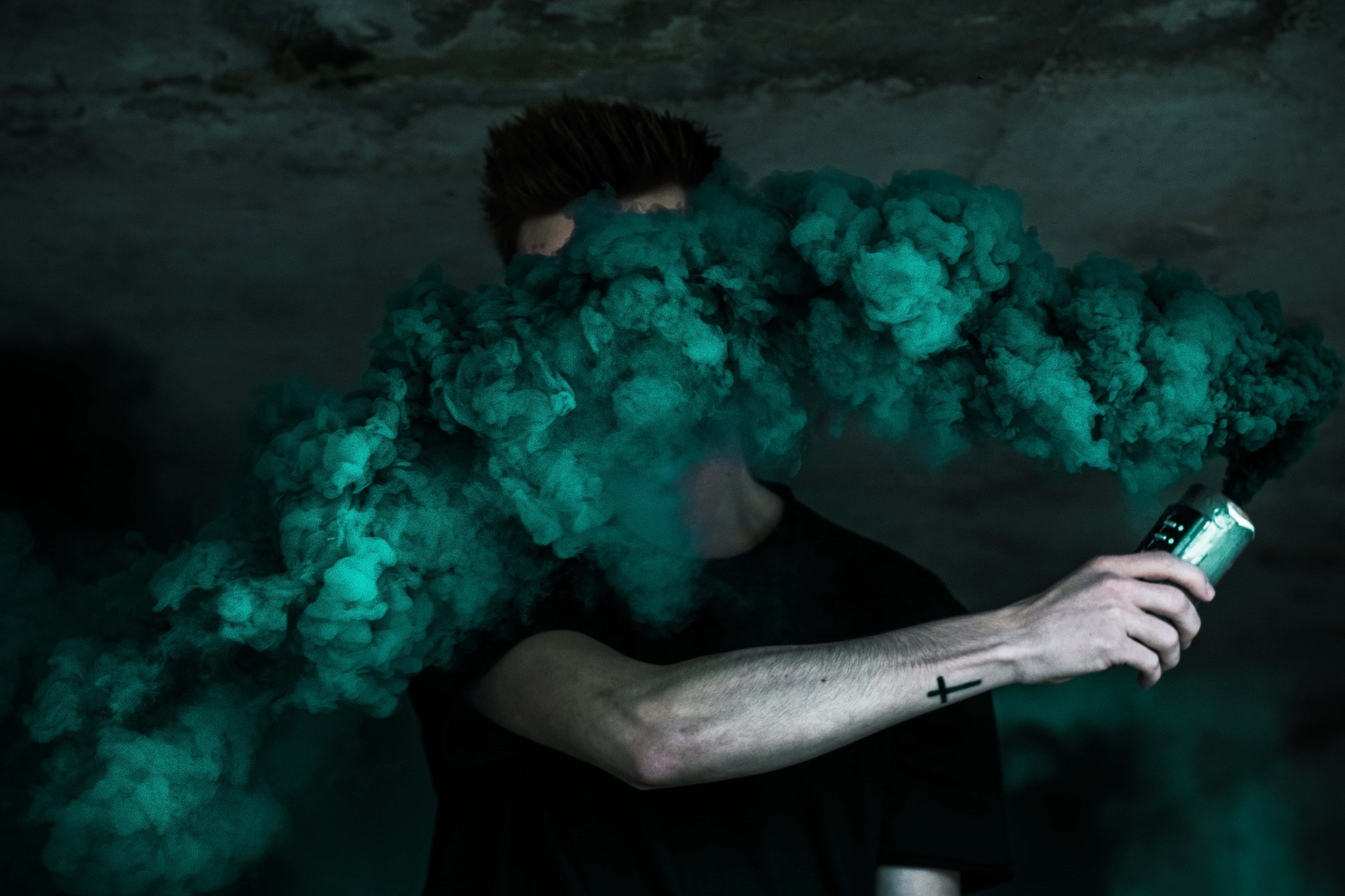 Bomb 桌布 壁紙 — 一個人在黑暗的房間裡，手持電子煙裝置，呼出一團濃密的青綠色煙霧。