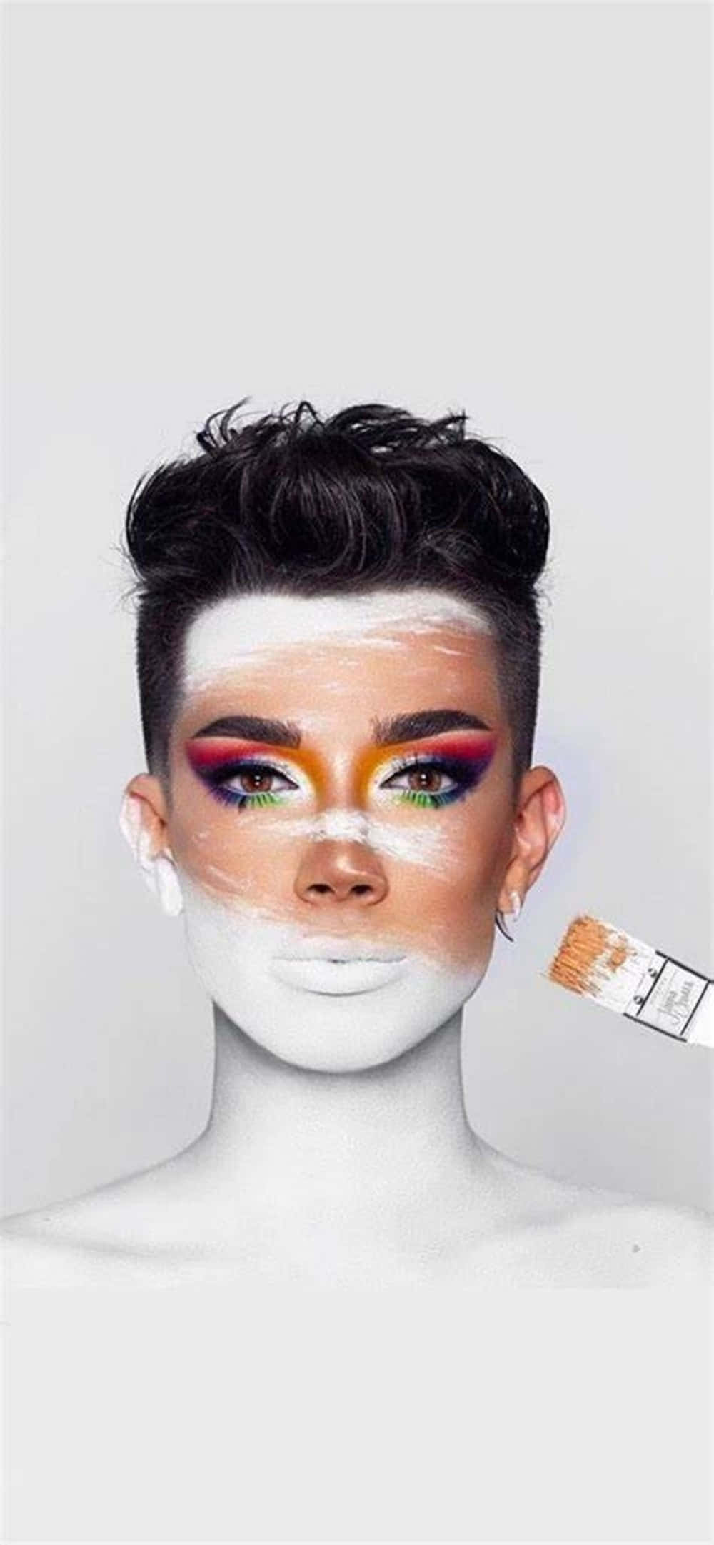 make up 桌布 壁紙 — 一個人帶有鮮豔的彩虹眼妝，白色顏料覆蓋半邊臉，同時用刷子塗抹更多顏料。
