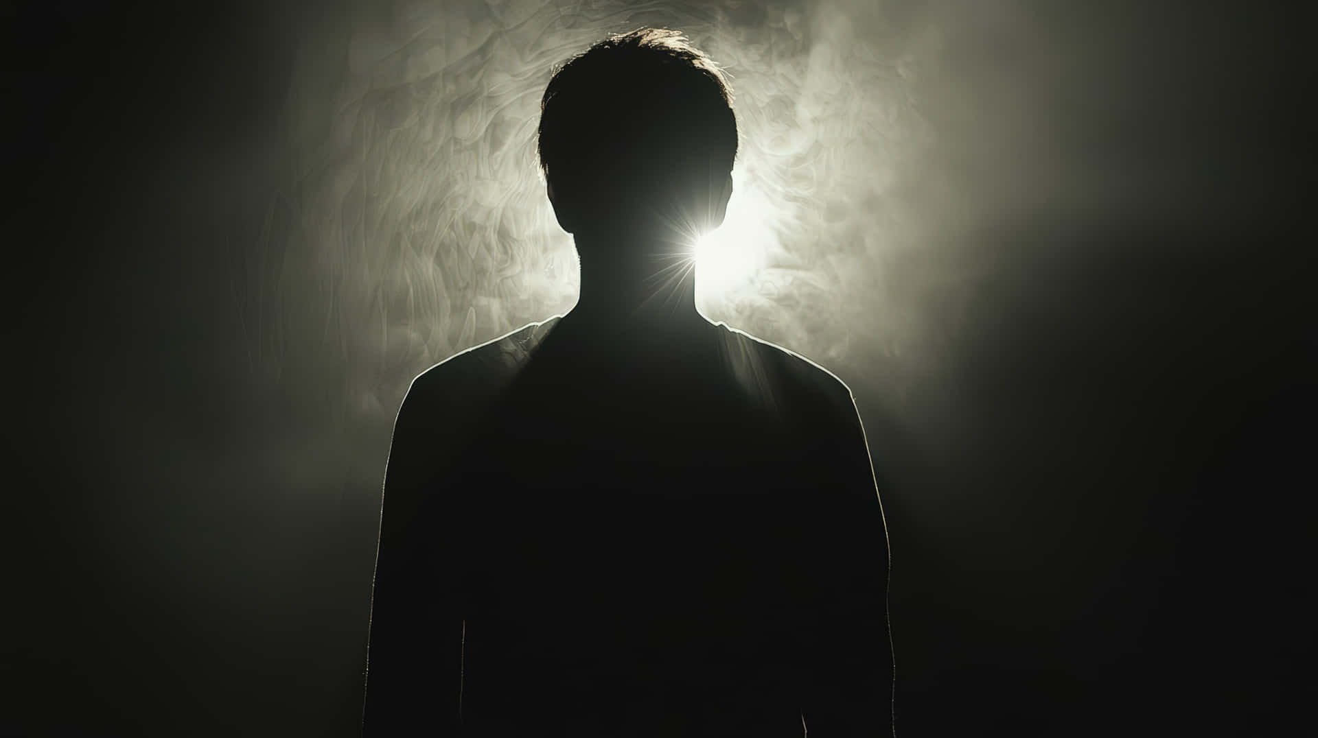 Dark silhouette of a man standing against a glowing backlight 壁紙 — 一個人形剪影背光而立，背後是明亮的陽光穿透旋轉的煙霧，映襯著黑暗的背景。