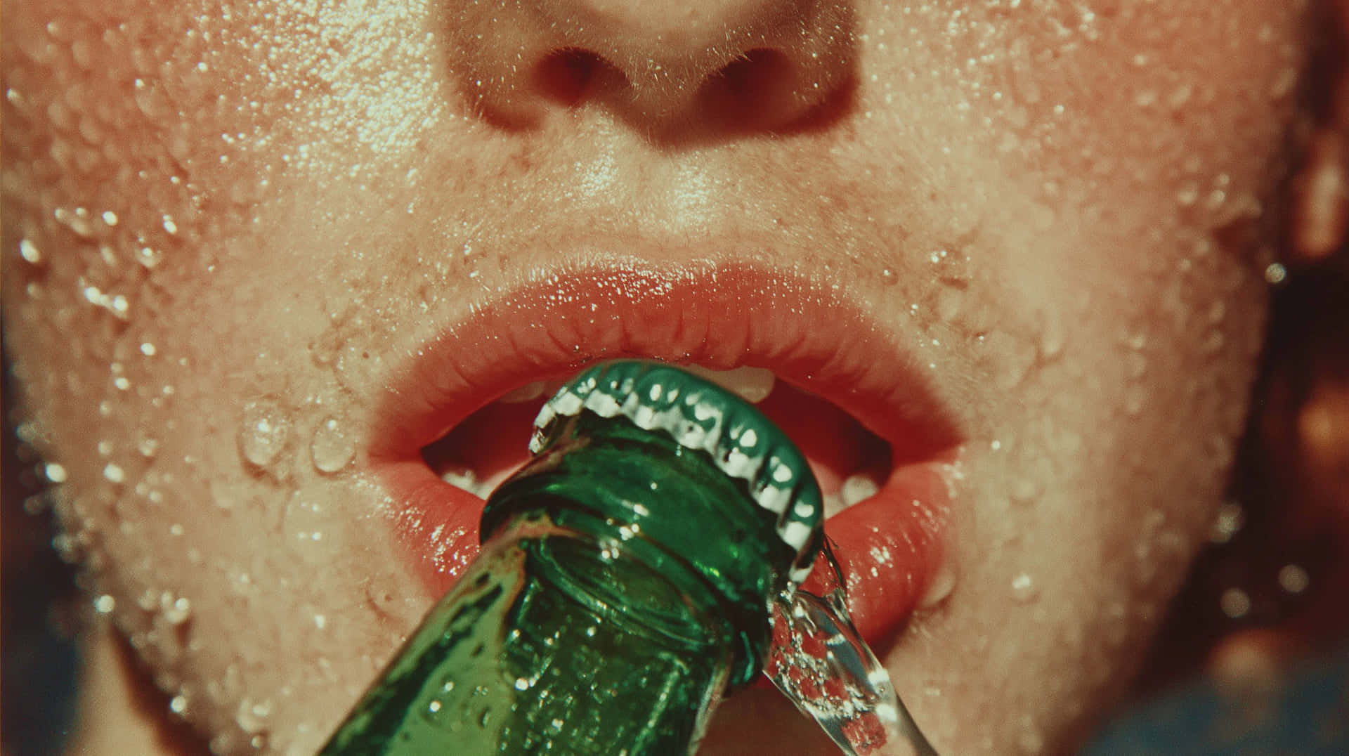 Close-Up of Refreshing Drink with Water Droplets on Sweaty Skin 壁紙 — 一個人從冰涼的綠色玻璃瓶飲用的特寫，皮膚和嘴唇上凝結著水珠。