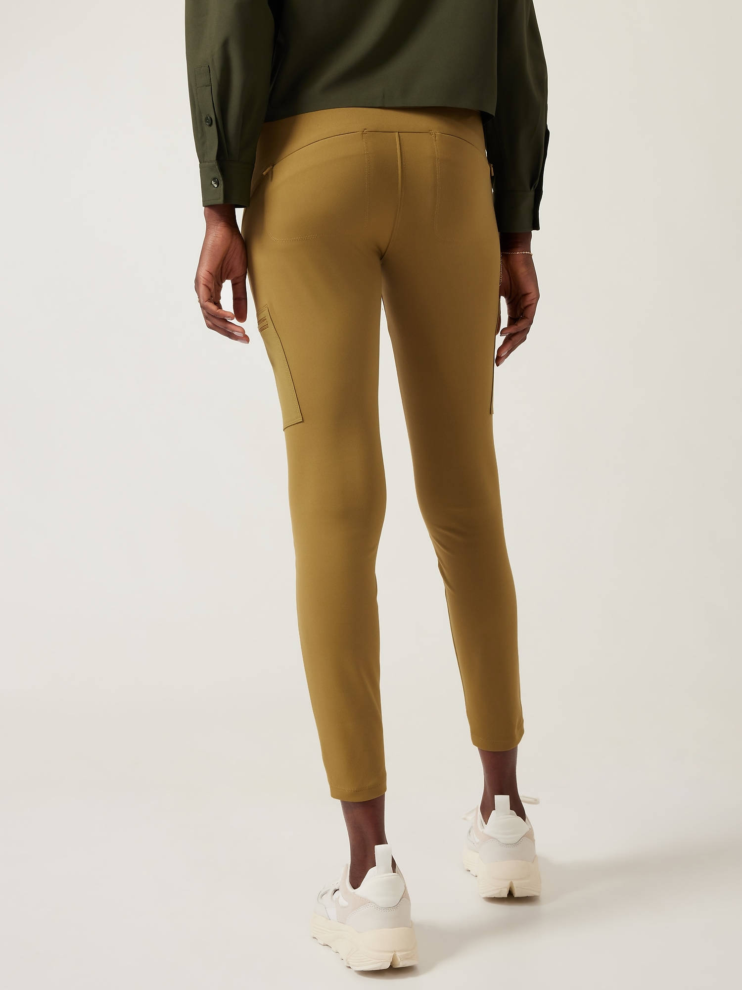 leggings 桌布 壁紙 — 一個人從背後看，穿著橄欖綠色褲子和白色運動鞋，背景是純白色。
