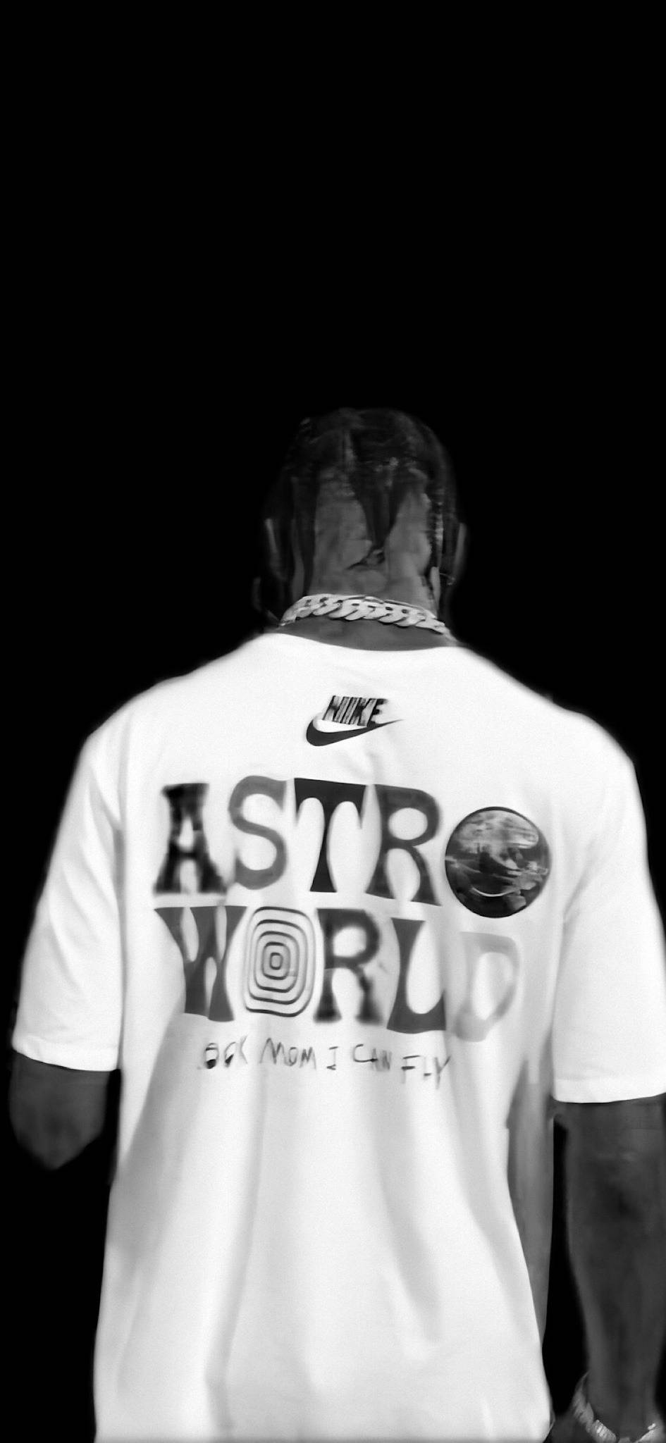 Travis Scott Aesthetic 桌布 壁紙 — 一個人從背後觀看，穿著白色Nike T恤，上面有「ASTRO WORLD」和地球圖案，背景是純黑色。