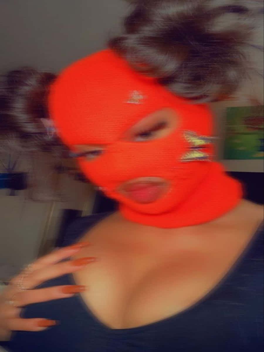 Ski Mask Girl 桌布 壁紙 — 一個人戴著亮橙色頭套，上面有星星貼片，並有濃密的深色頭髮梳成髮髻。