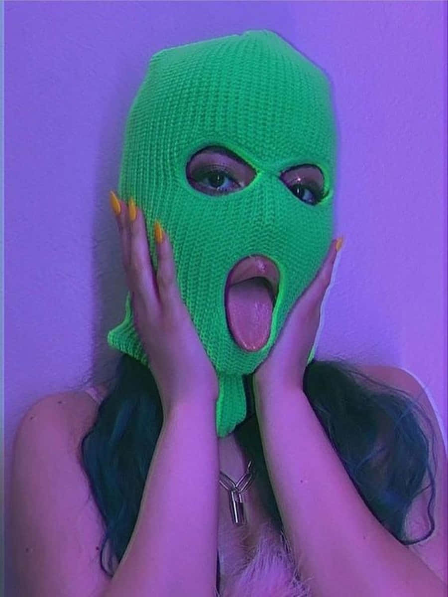 Ski Mask Girl 桌布 壁紙 — 一個人戴著亮綠色針織巴拉克拉法帽，雙手托腮，背景是紫色燈光牆壁。