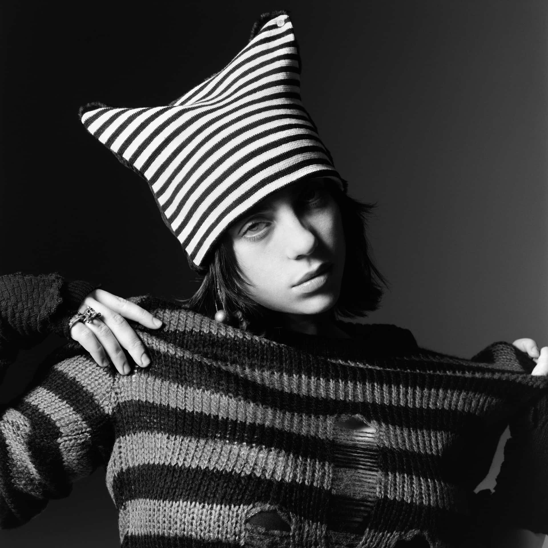 Billie Eilish 2021 桌布 壁紙 — 一個人戴著星形條紋帽，並將條紋毛衣拉過肩膀，呈現鮮明的黑白肖像。