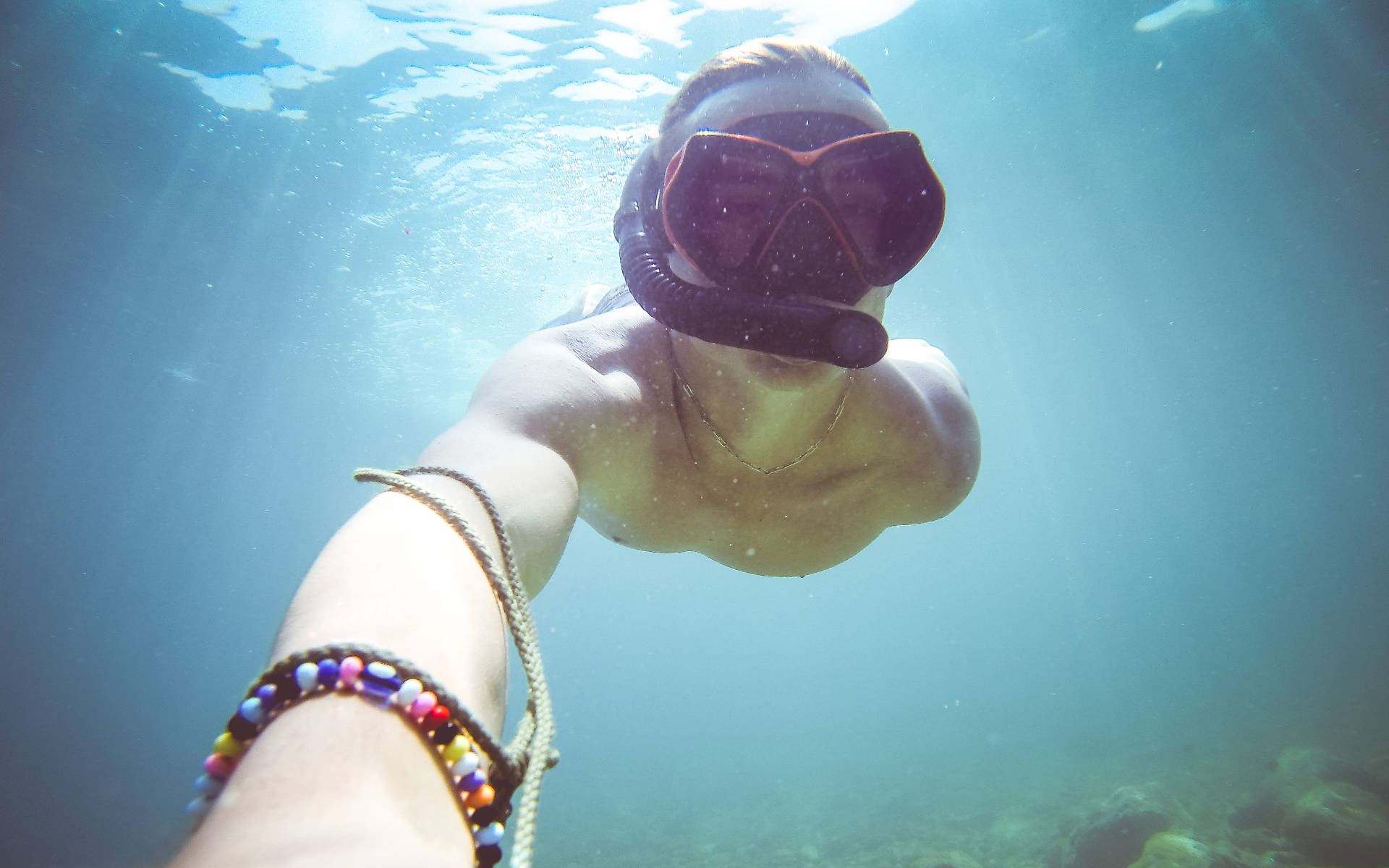 Swimming 桌布 壁紙 — 一個人戴著潛水鏡在藍色水底游泳，陽光穿過水面照射下來。
