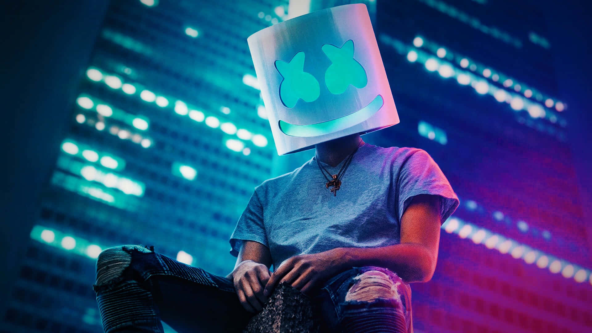 Marshmello 動態圖 桌布 壁紙 — 一個人戴著發光的Marshmello頭盔，坐在夜晚充滿活力的霓虹燈城市景觀前。