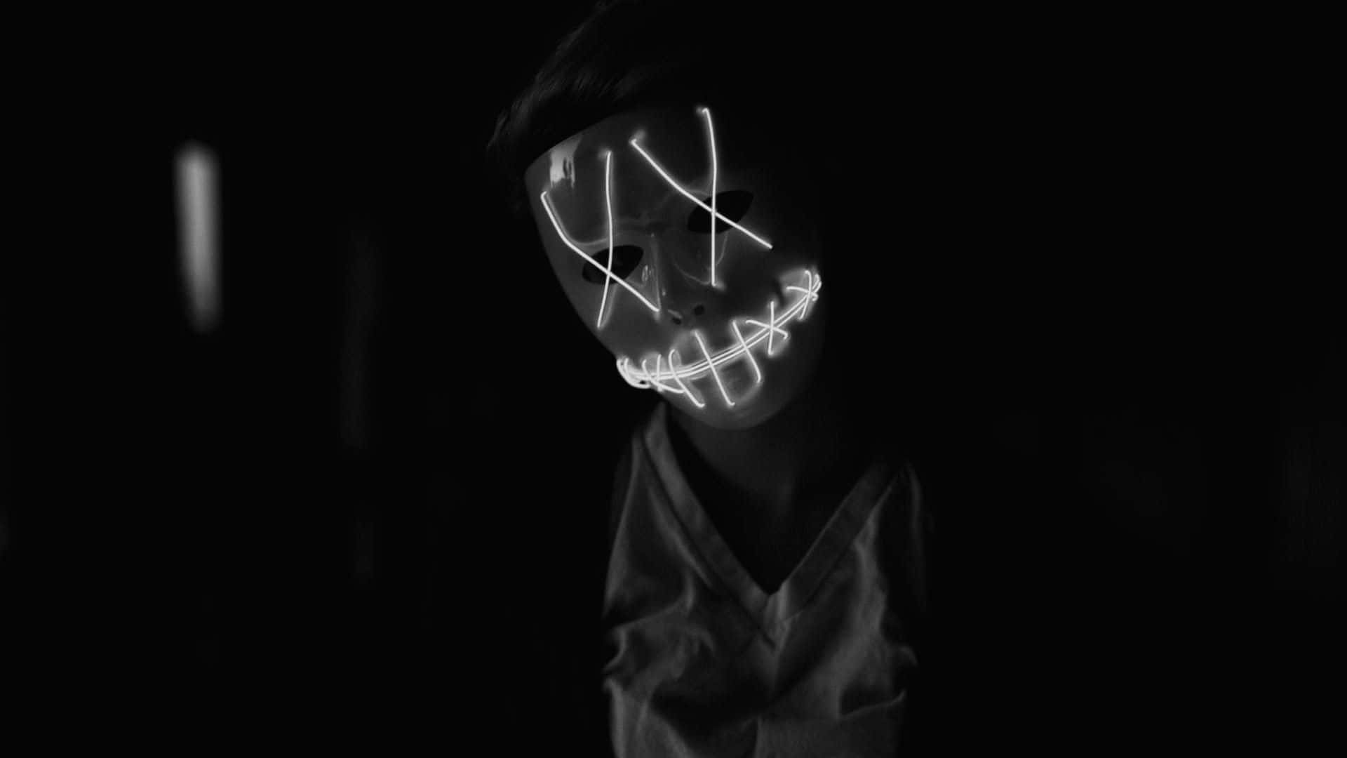 Horror Masks 桌布 壁紙 — 一個人戴著發光的白色LED面具，嘴巴被縫合，眼睛交叉，從完全的黑暗中凝視。