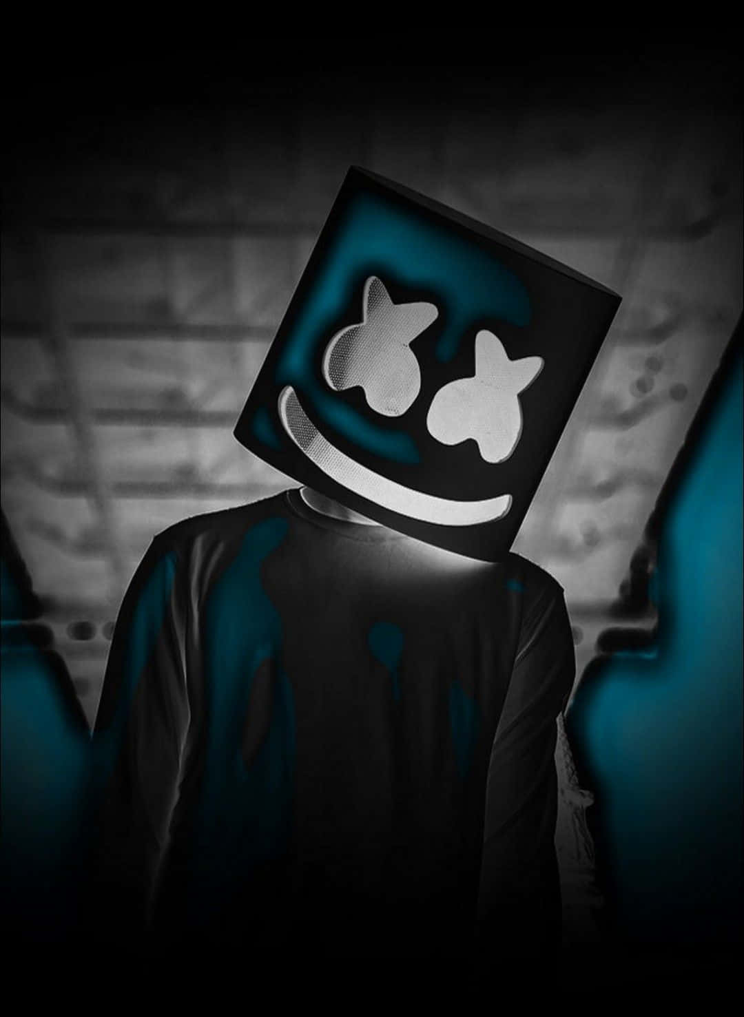 marshmello iPhone 桌布 壁紙 — 一個人戴著發光的藍白方形面具，有星星眼睛和微笑，站在深色磚牆前。