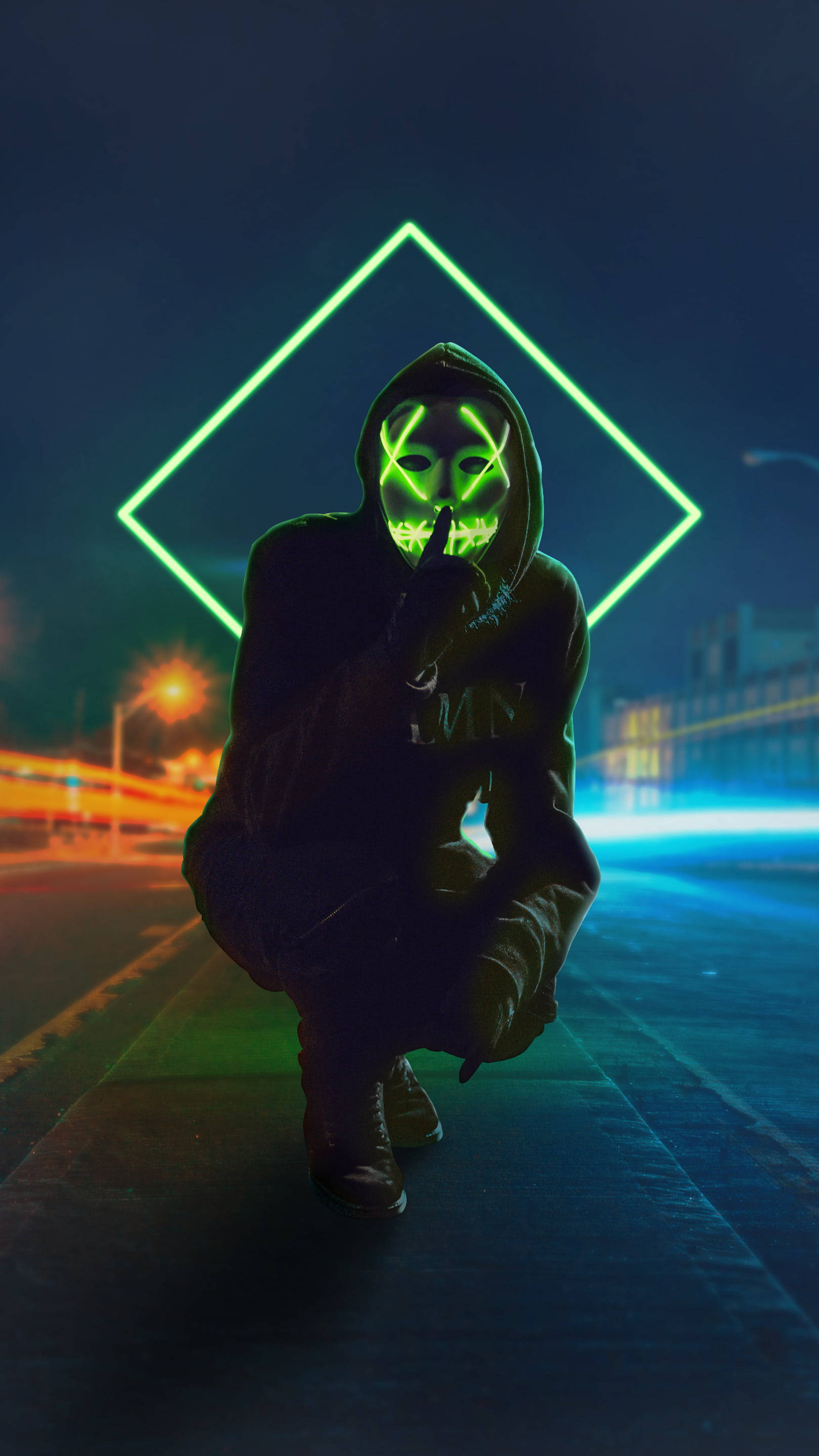 Purge 桌布 壁紙 — 一個人戴著發光綠色骷髏面具，在夜晚霓虹燈照亮的城市街道上蹲著，身後有一個鑽石形狀的光。