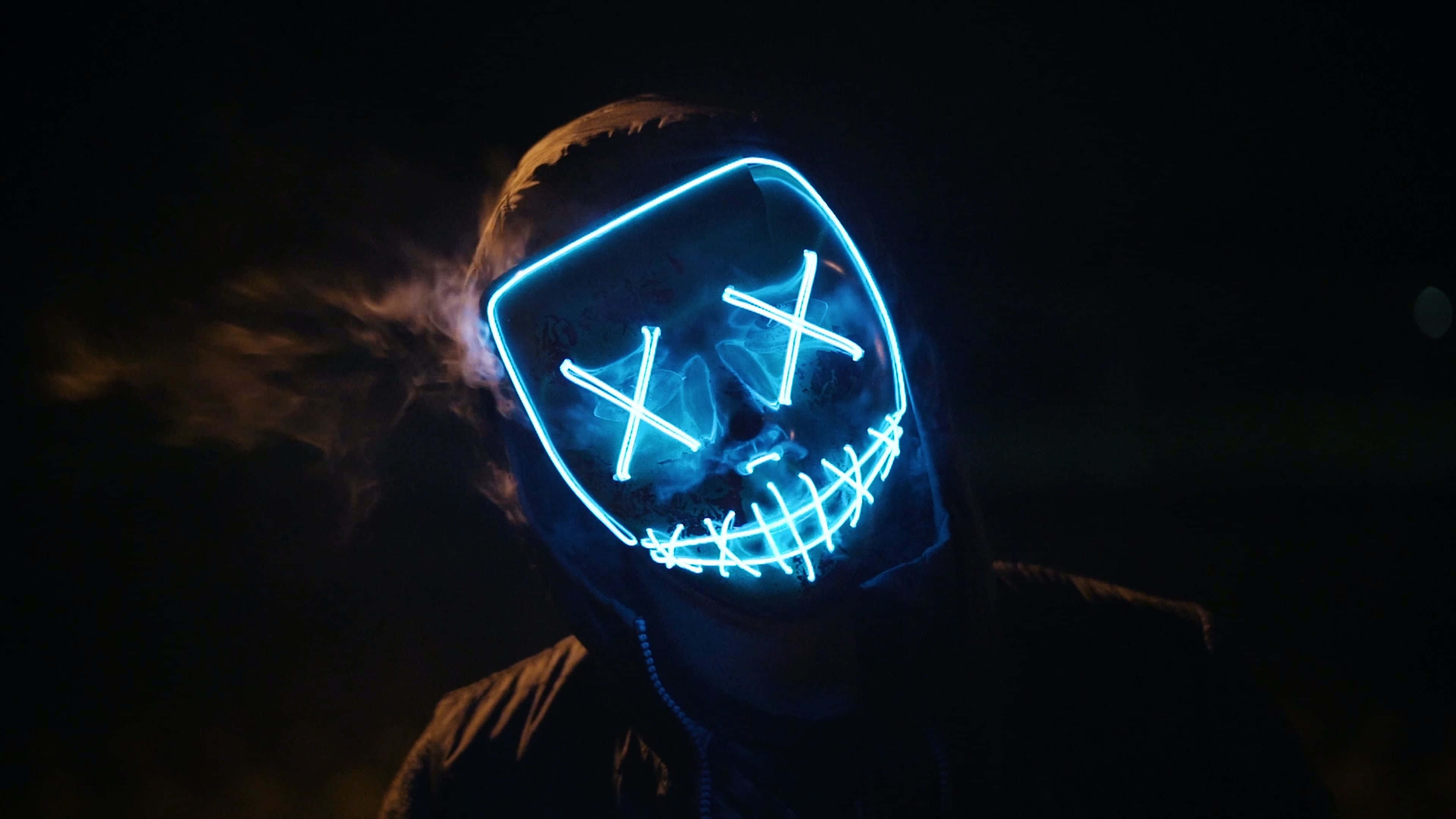 Mask 桌布 壁紙 — 一個人戴著發光藍色LED面具，眼睛呈X形，嘴巴縫合，在黑暗背景中呼出煙霧。