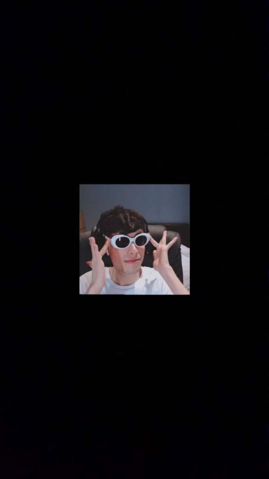Sunglasses 桌布 壁紙 — 一個人戴著白色太陽眼鏡和耳機，在深色背景前做出和平手勢。