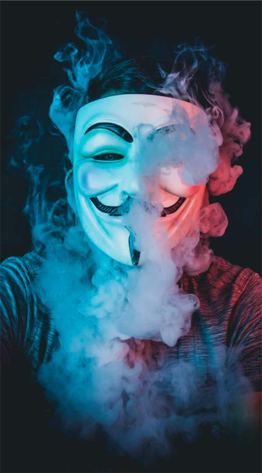 匿名 桌布 壁紙 — 一個人戴著白色蓋伊·福克斯面具，在黑暗背景下呼出旋轉的藍色和紅色煙霧。