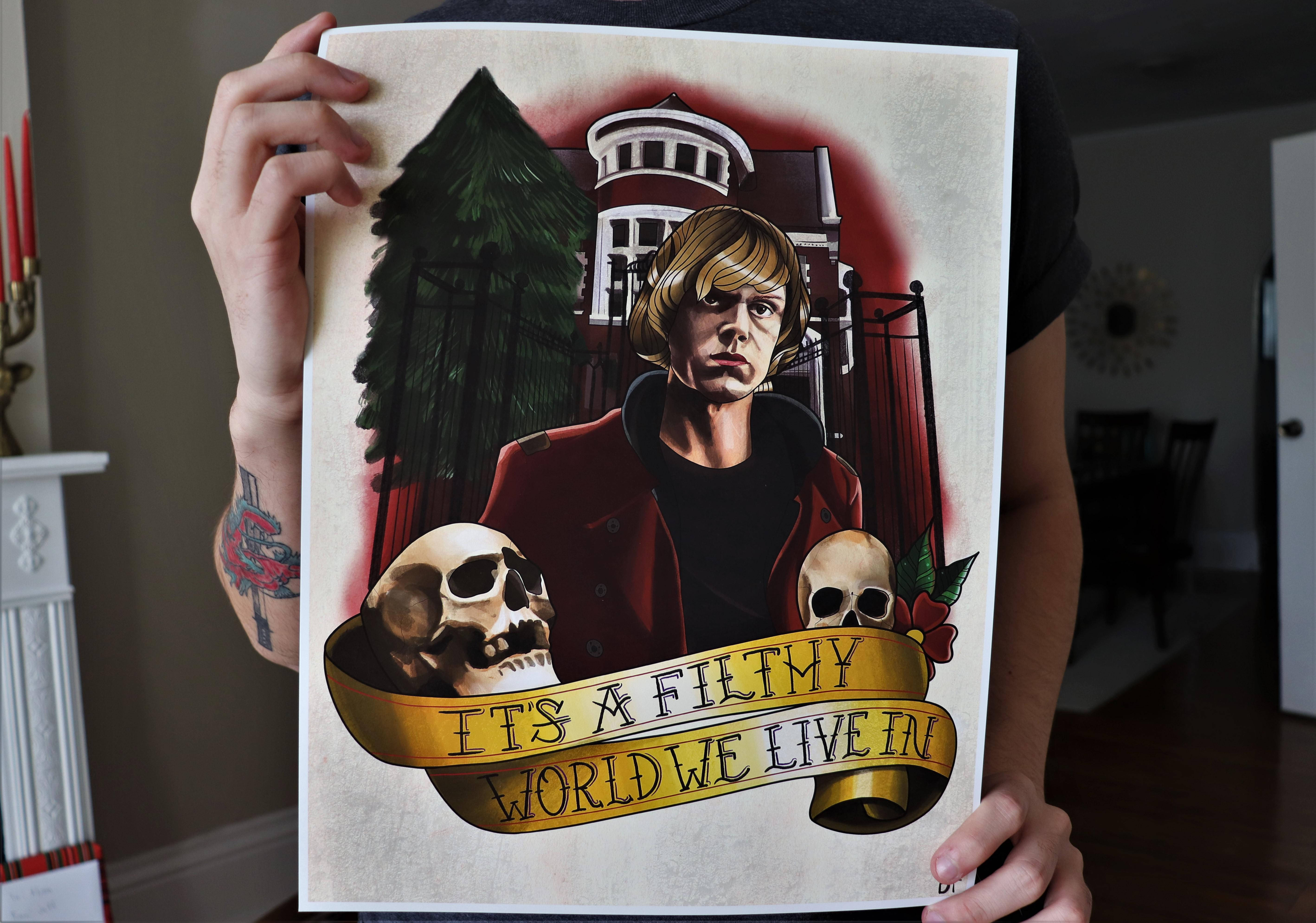 Tate Langdon 桌布 壁紙 — 一個人手持一幅鮮明的紋身風格插圖，圖中有一個穿著紅色外套的男人、骷髏頭和一條寫著「It's a Filthy World We Live In」的橫幅，背景是鬼屋。