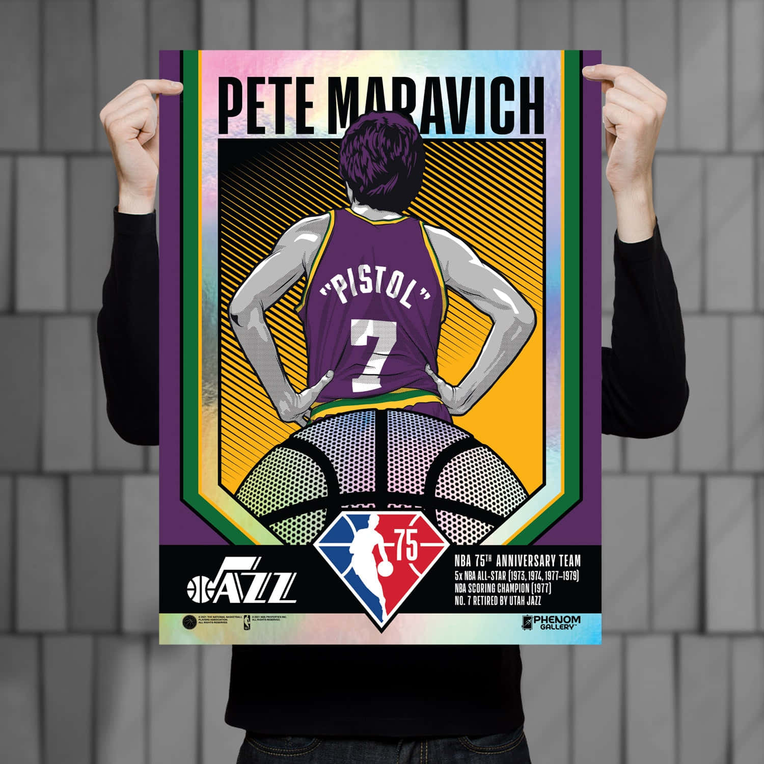 NBA 桌布 壁紙 — 一個人手持一張色彩鮮豔的Pete Maravich海報，他穿著紫色「Pistol」球衣，拿著籃球，周圍是彩色幾何邊框。