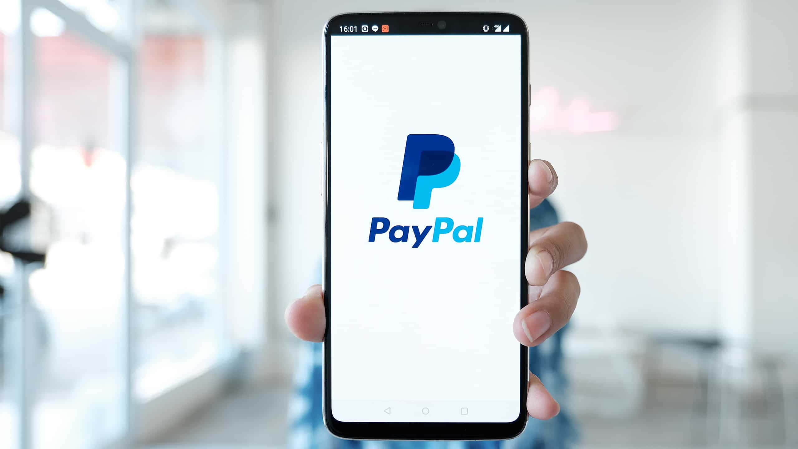 一個人手持帶有Paypal標誌的手機 壁紙
