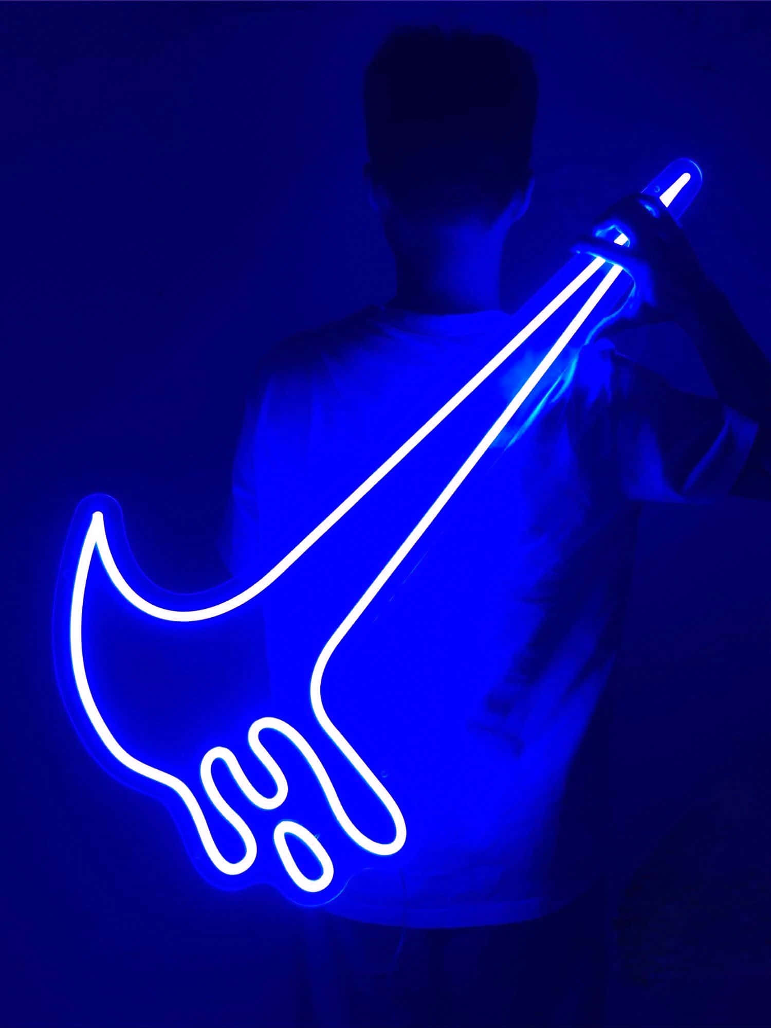 Blue Nike 桌布 壁紙 — 一個人手持發光藍色霓虹吉他輪廓，背景黑暗，散發出充滿活力的電光藍色光芒。