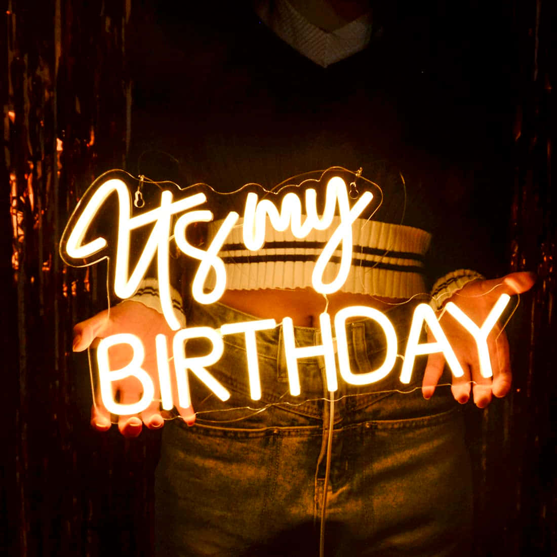 Birthday 桌布 壁紙 — 一個人手持發光霓虹燈牌，上面寫著「是我的生日」，背景是黑暗的閃爍金箔。
