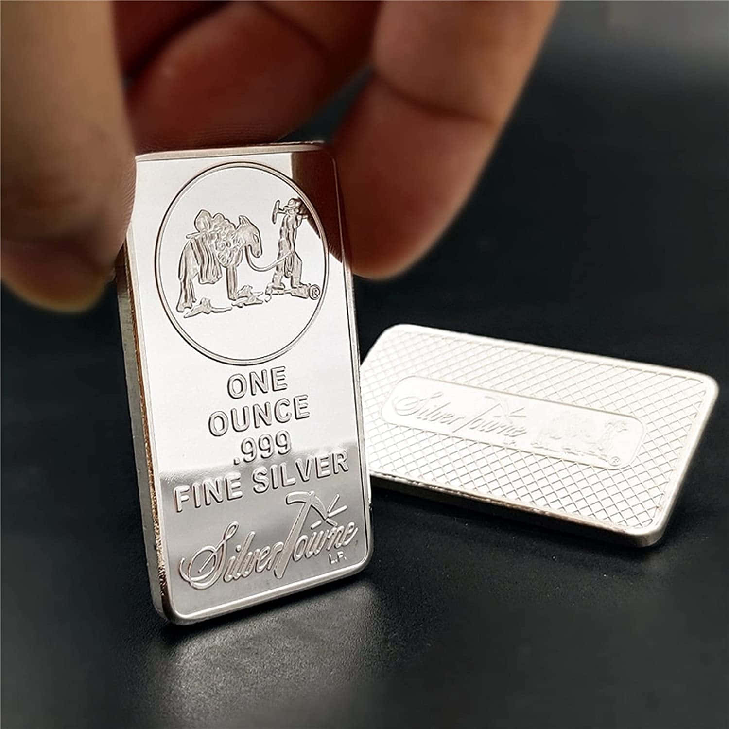 一個人手持銀條，旁邊放著一個小盒子 壁紙