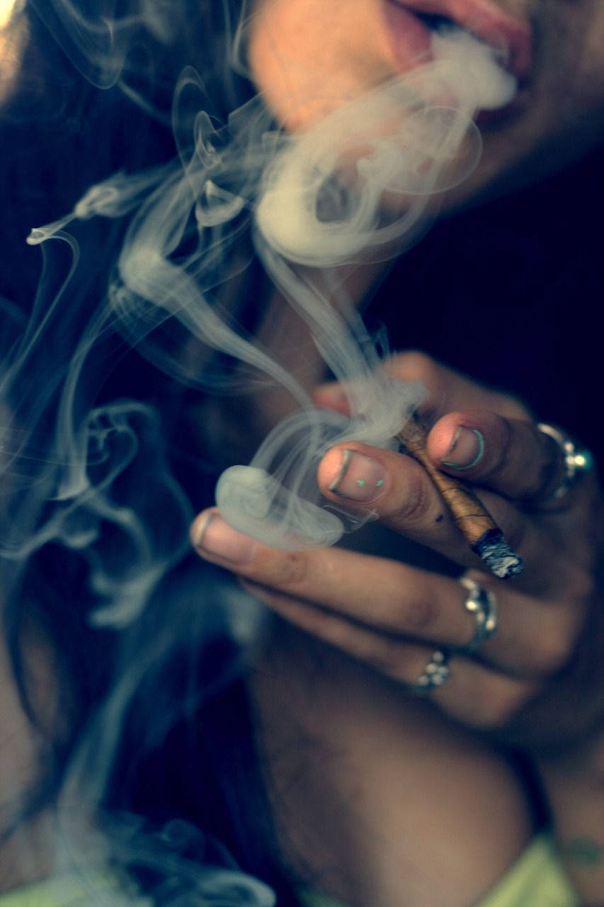 Blunt 桌布 壁紙 — 一個人手持點燃的雪茄，戴著戒指和塗了指甲油的手指，呼出煙霧的特寫。