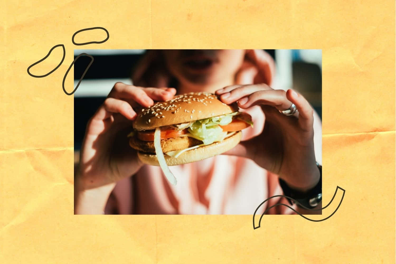 fast food 桌布 壁紙 — 一個人拿著一個芝麻漢堡，配有生菜、番茄和洋蔥，背景是溫暖的黃色紙張，帶有塗鴉裝飾。