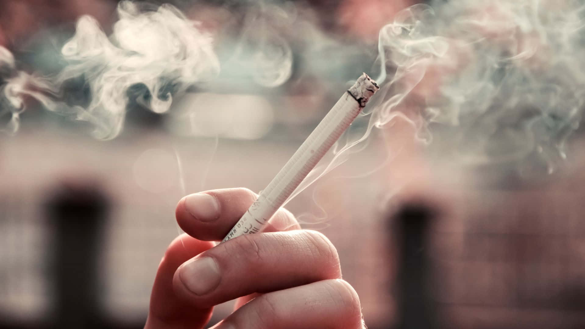 一個人拿著香菸，菸菸裊裊升起 壁紙