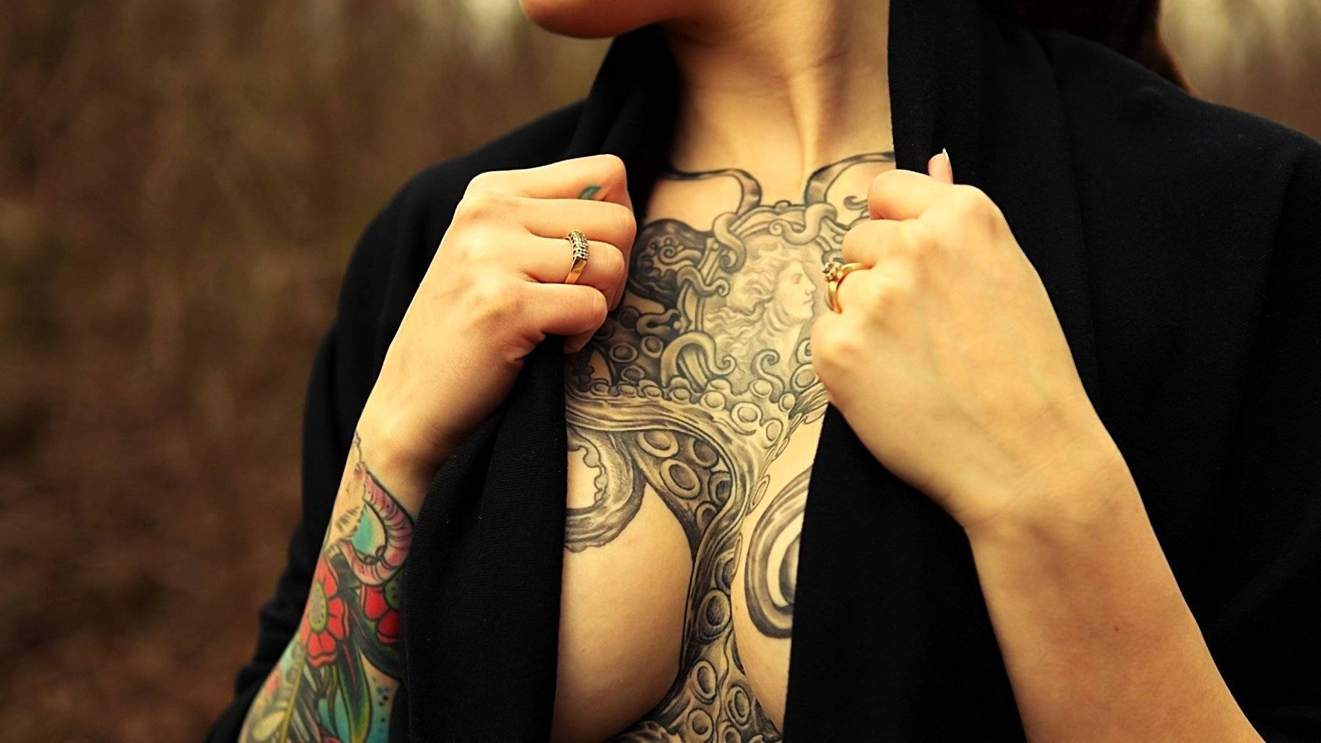 Tattoo 桌布 壁紙 — 一個人掀起黑色西裝外套，露出胸前和肩膀上蔓延的複雜黑色墨水章魚紋身。
