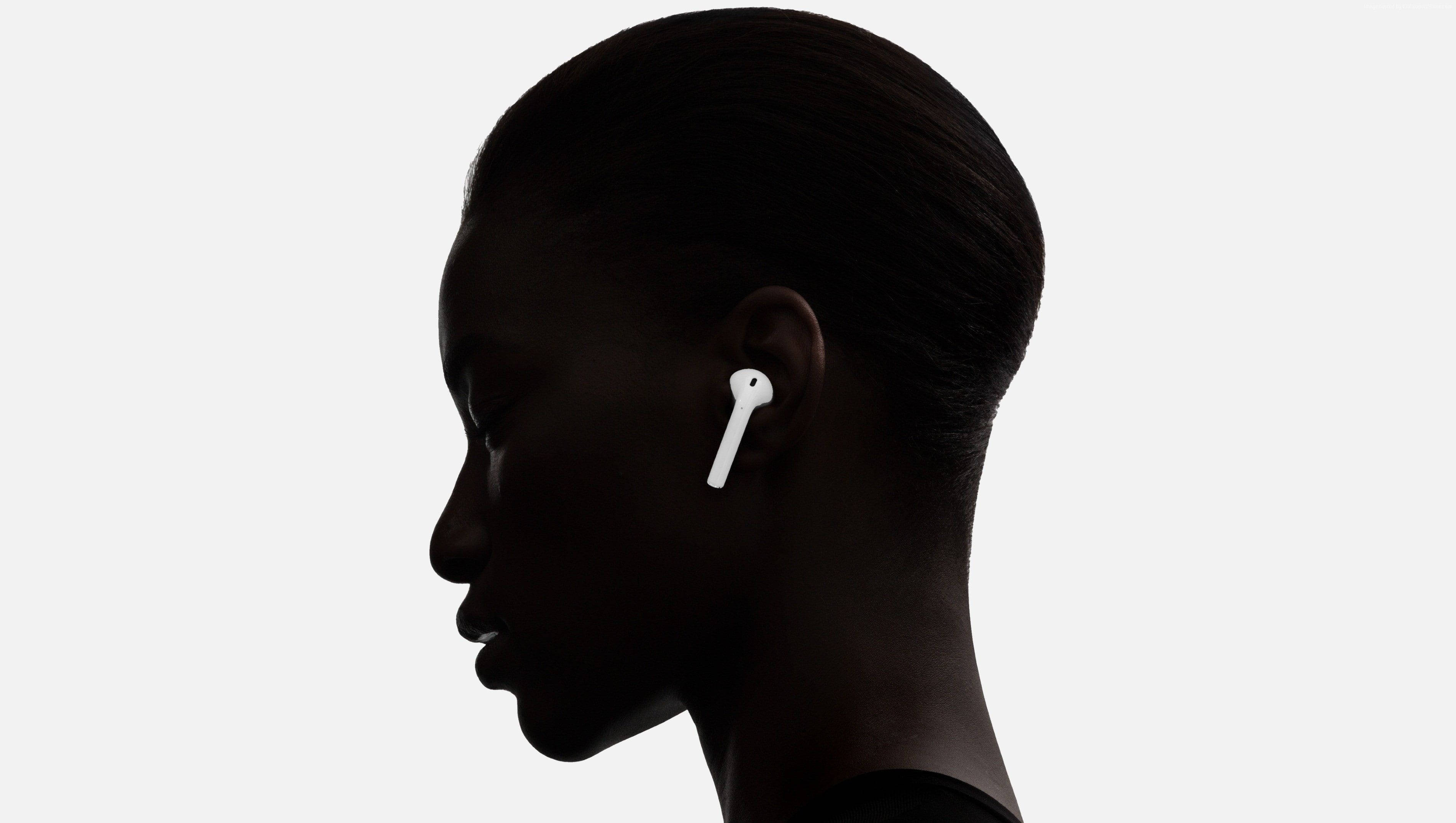 AirPods 桌布 壁紙 — 一個人的側面剪影，戴著白色無線耳機，背景是純色淺色。