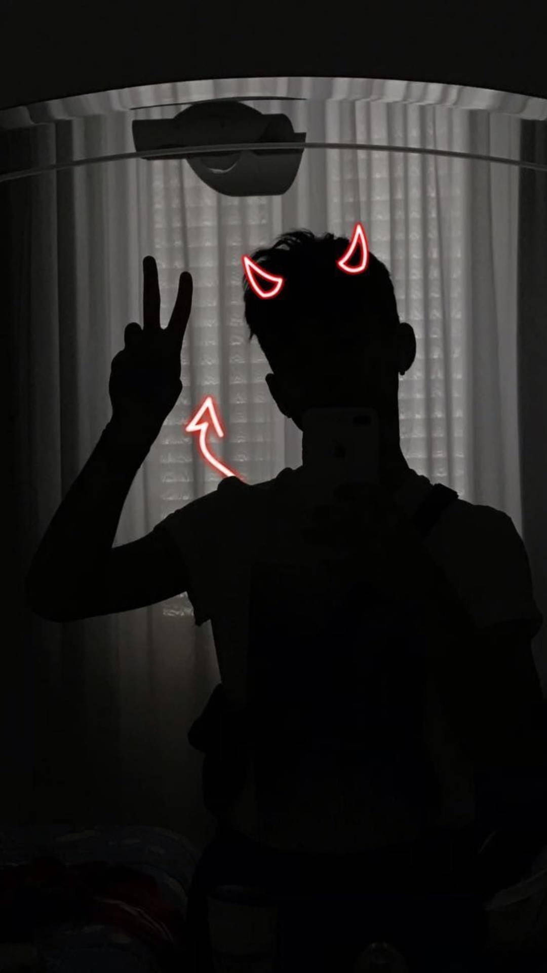 一個人在黑暗的房間裡，帶著發光的紅色惡魔角做出和平手勢。 — 惡魔動圖 壁紙