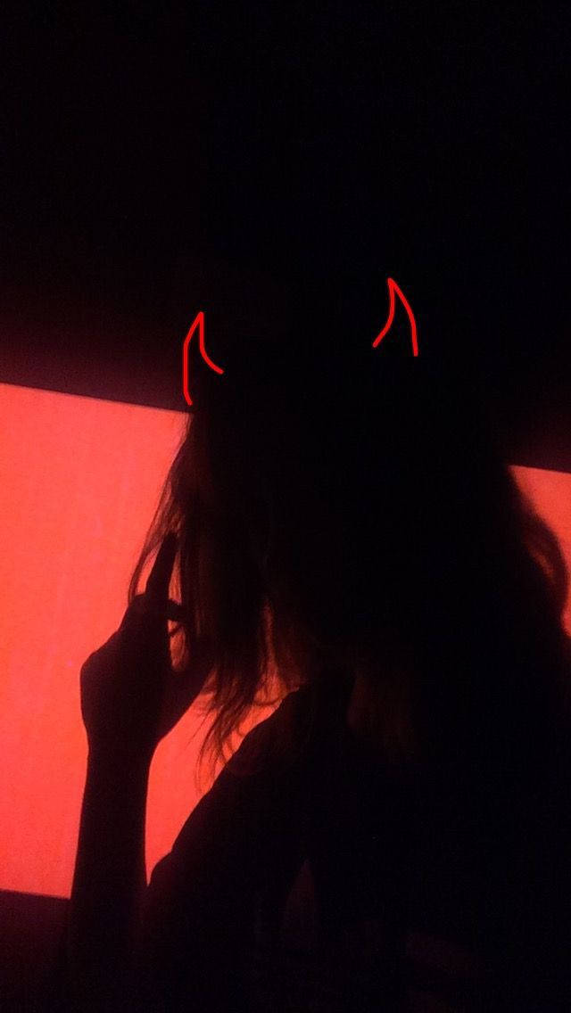 Neon Red Aesthetic 桌布 壁紙 — 一個人的剪影，戴著發光的紅色惡魔角，背景是暗紅色燈光牆壁。