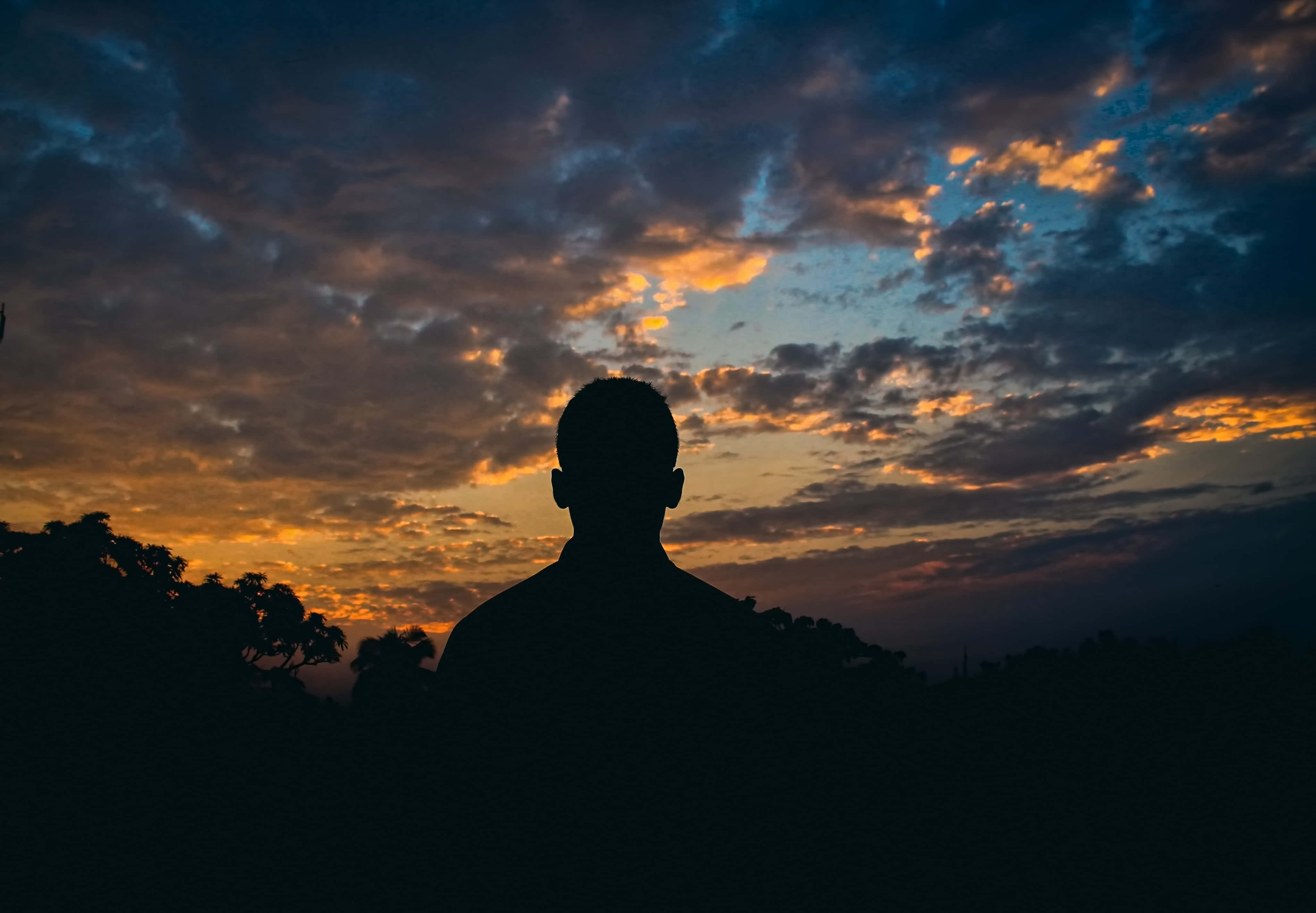 Alone 桌布 壁紙 — 一個人的剪影，站在一個充滿橙色和藍色雲的戲劇性暮色天空前面。