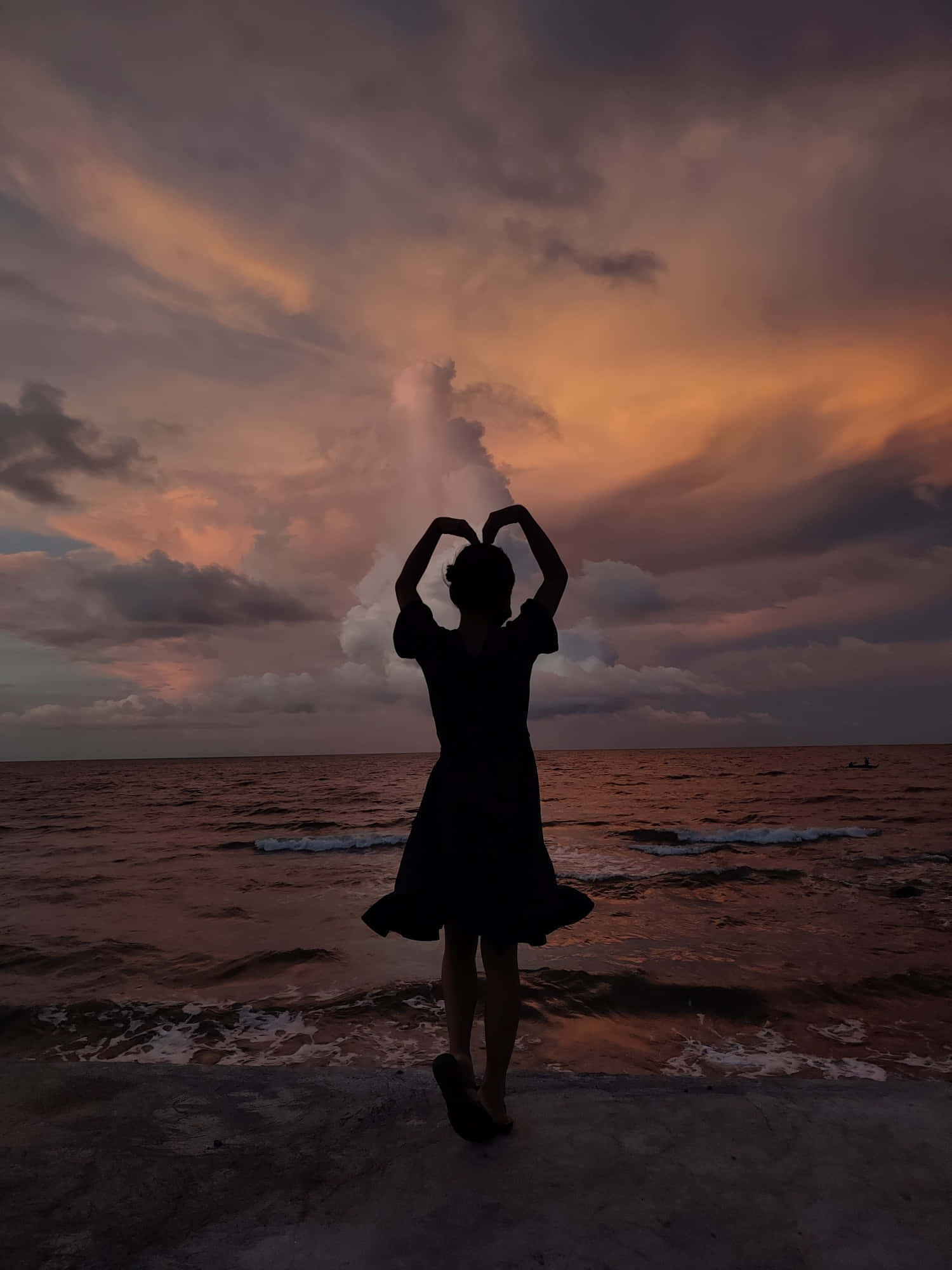 Heart Silhouette 桌布 壁紙 — 一個人的剪影，雙手形成心形，背景是海洋上戲劇性的日落。